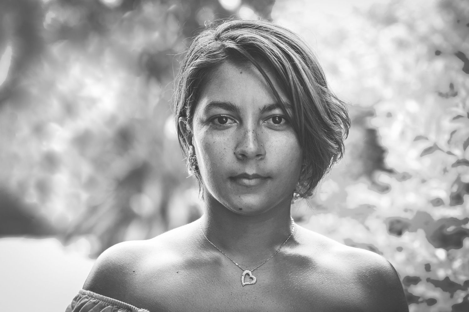 Soft black and white portrait with natural lighting and bokeh background.