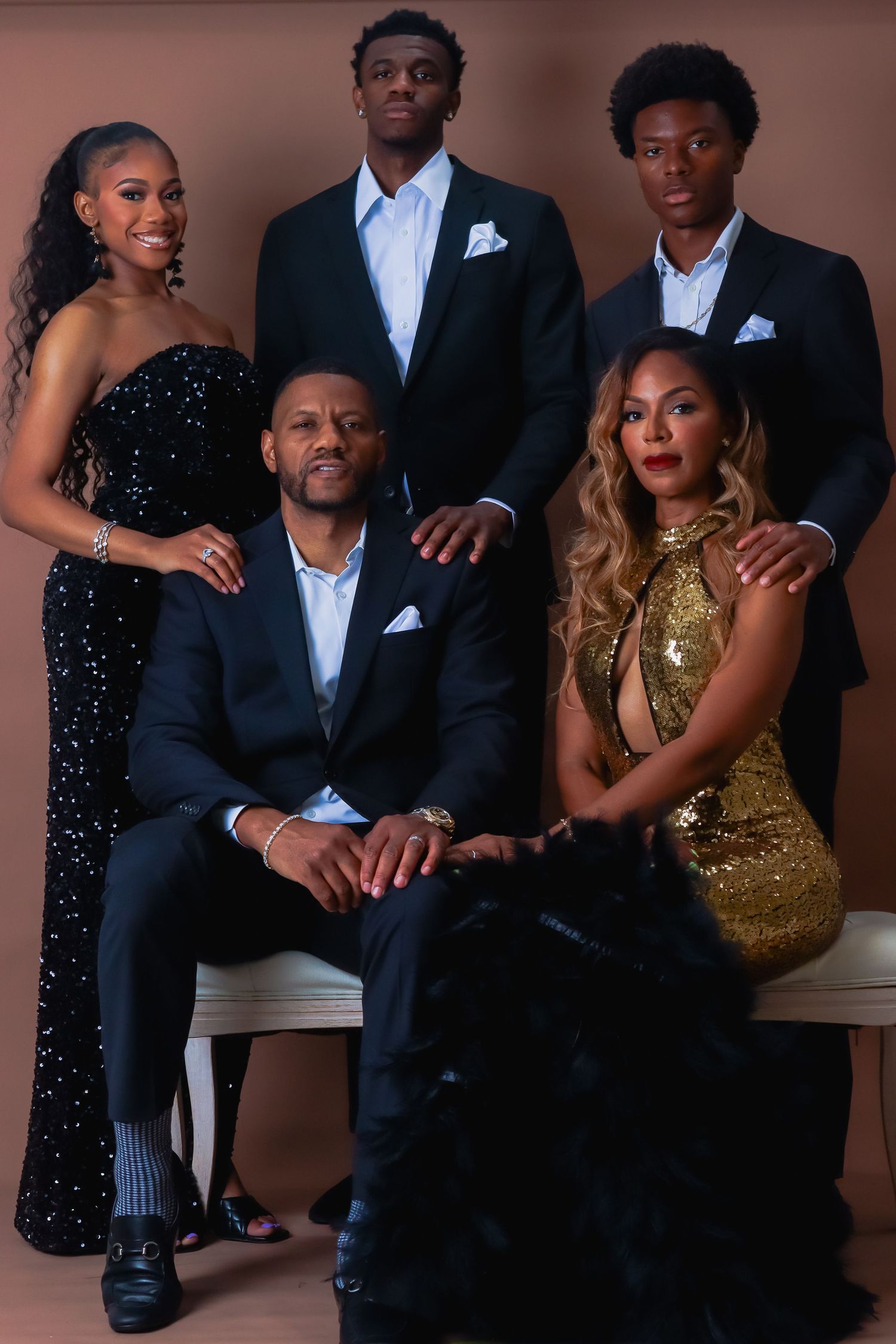 Elegant formal photoshoot featuring couples in evening wear with black suits and sparkly gold and black dresses.