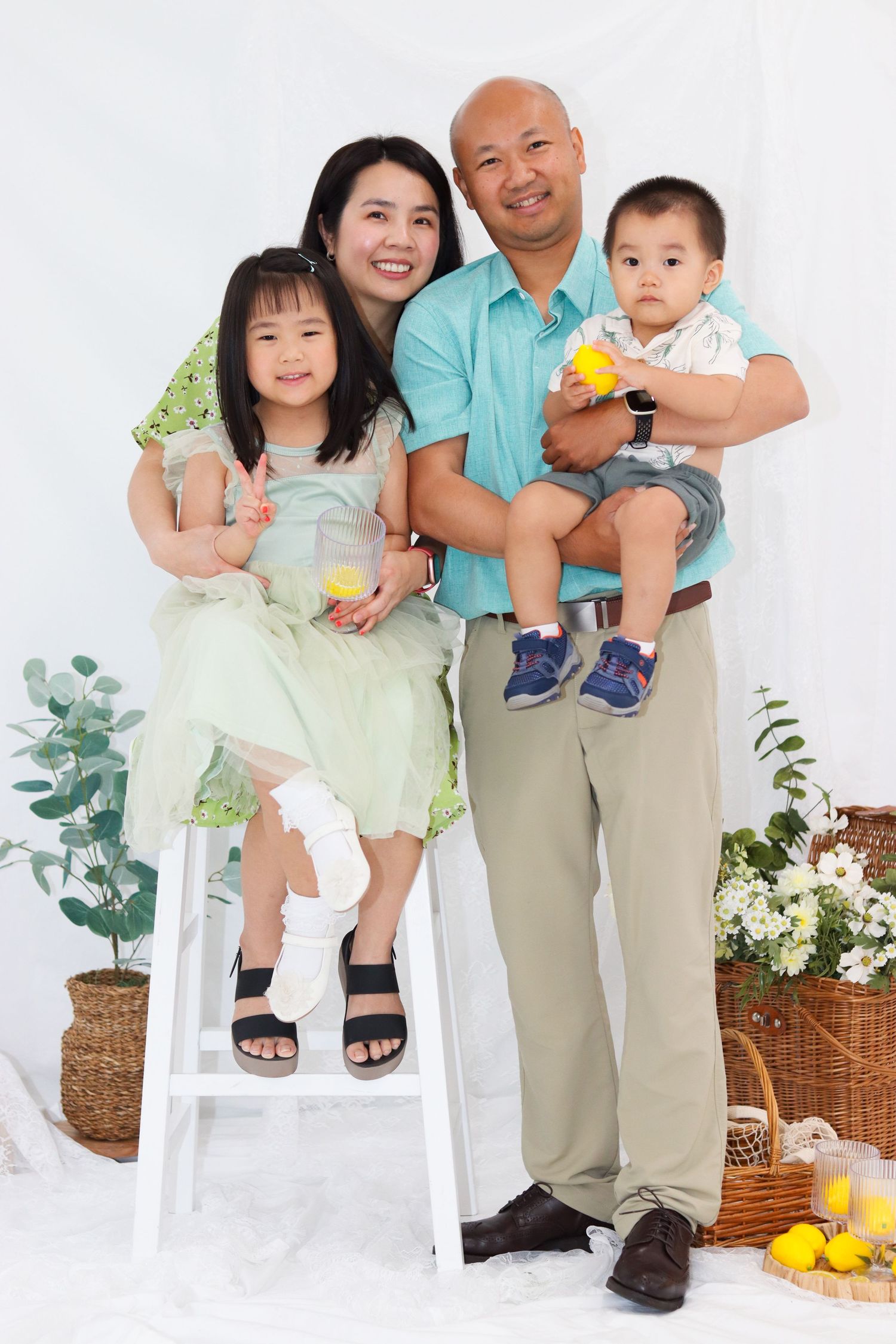 Family portrait series in white studio with parents and child wearing coordinated casual outfits.
