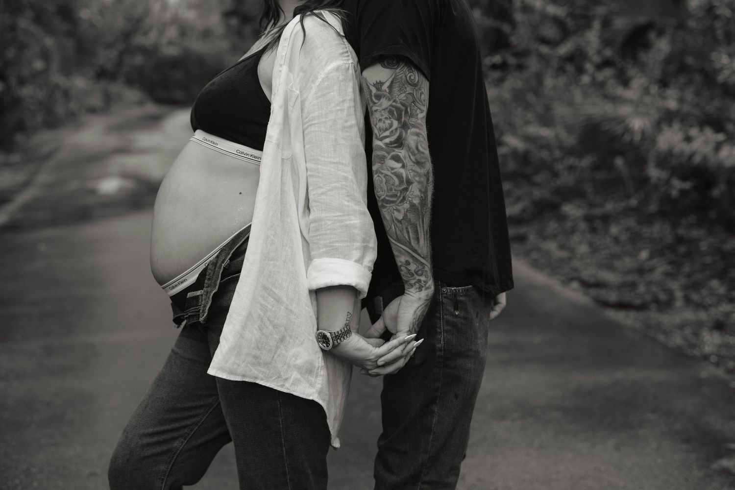 A romantic couple embraces in a black and white outdoor photoshoot series.