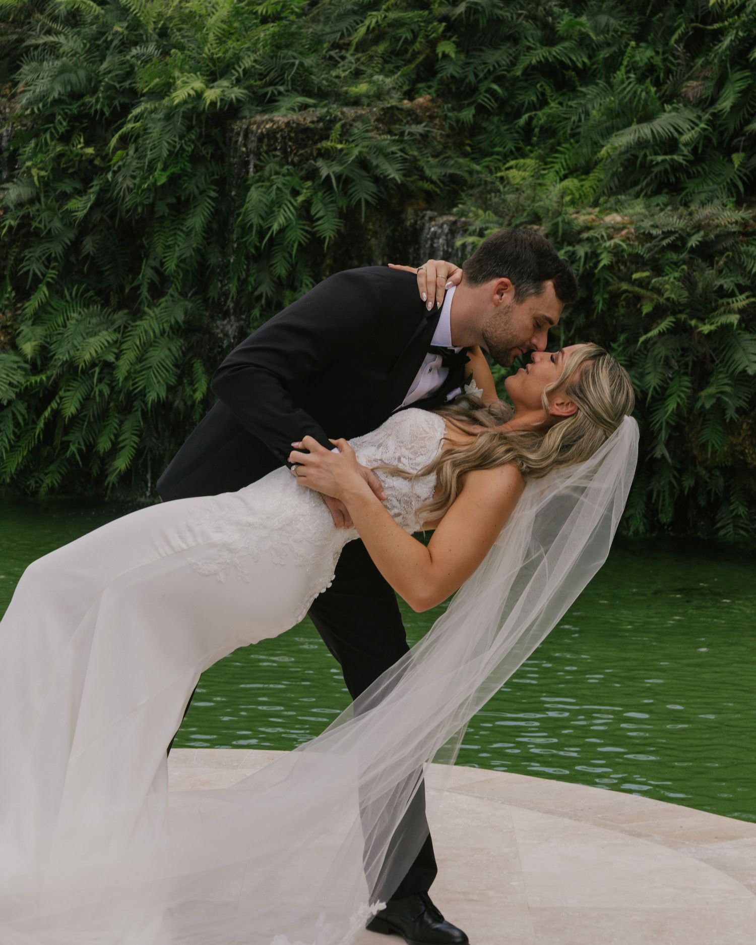 Romantic wedding couple shares passionate kisses in a series of photos against lush green garden backdrop.