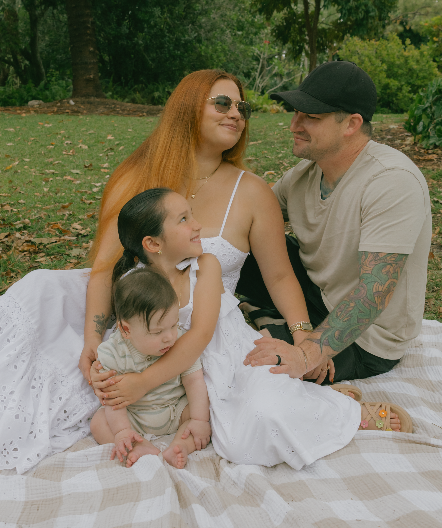 Intimate family moments captured on white blanket during outdoor photoshoot.