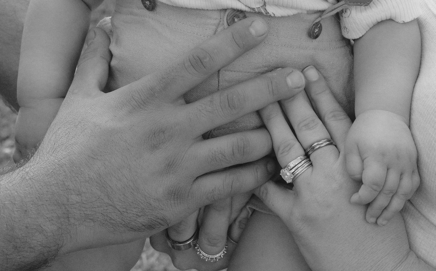 A series of black and white photographs showing hands with wedding rings and engagement rings.