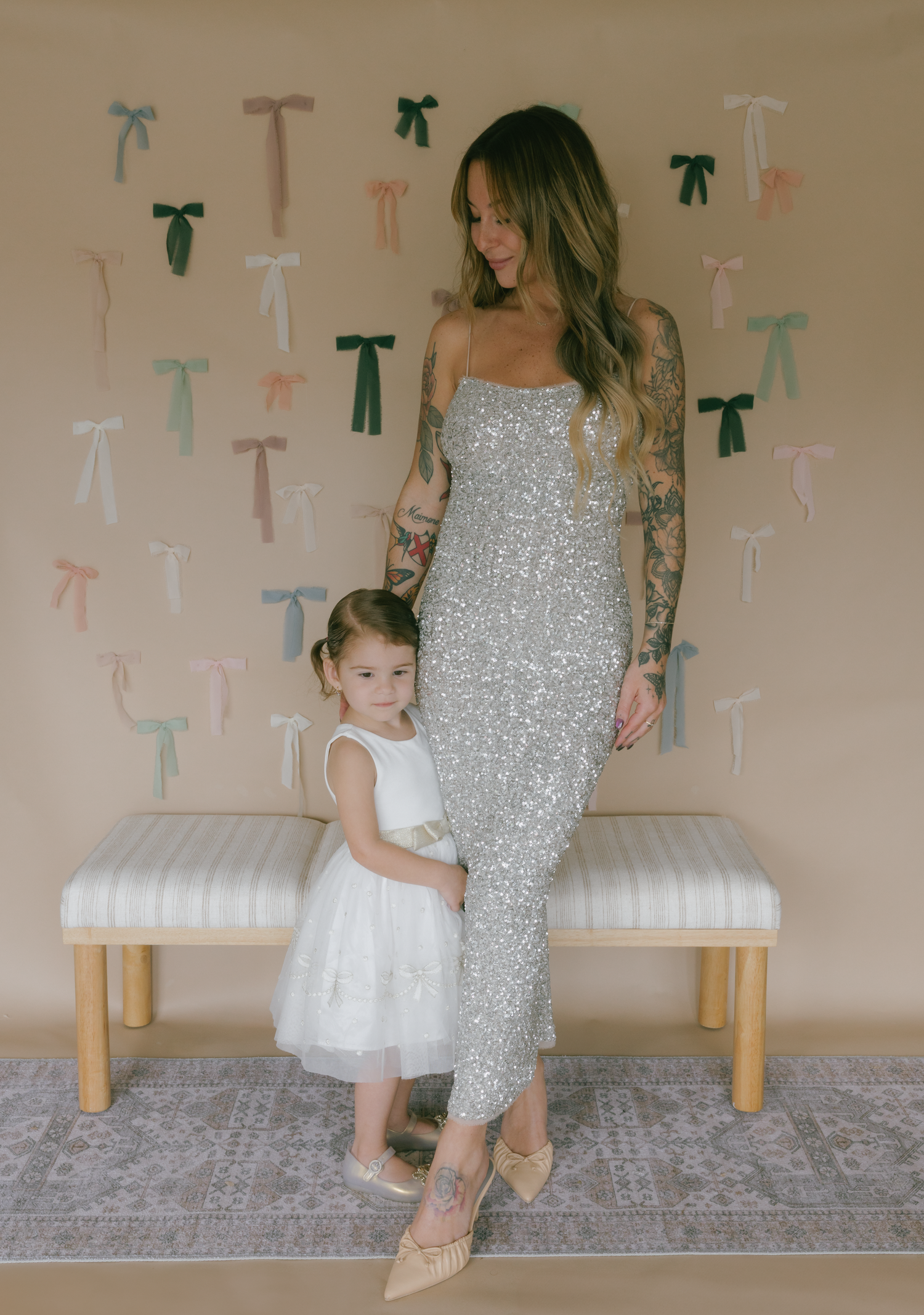 A series of photos showing a sweet interaction between a child in white dress and someone wearing a sparkly silver dress.