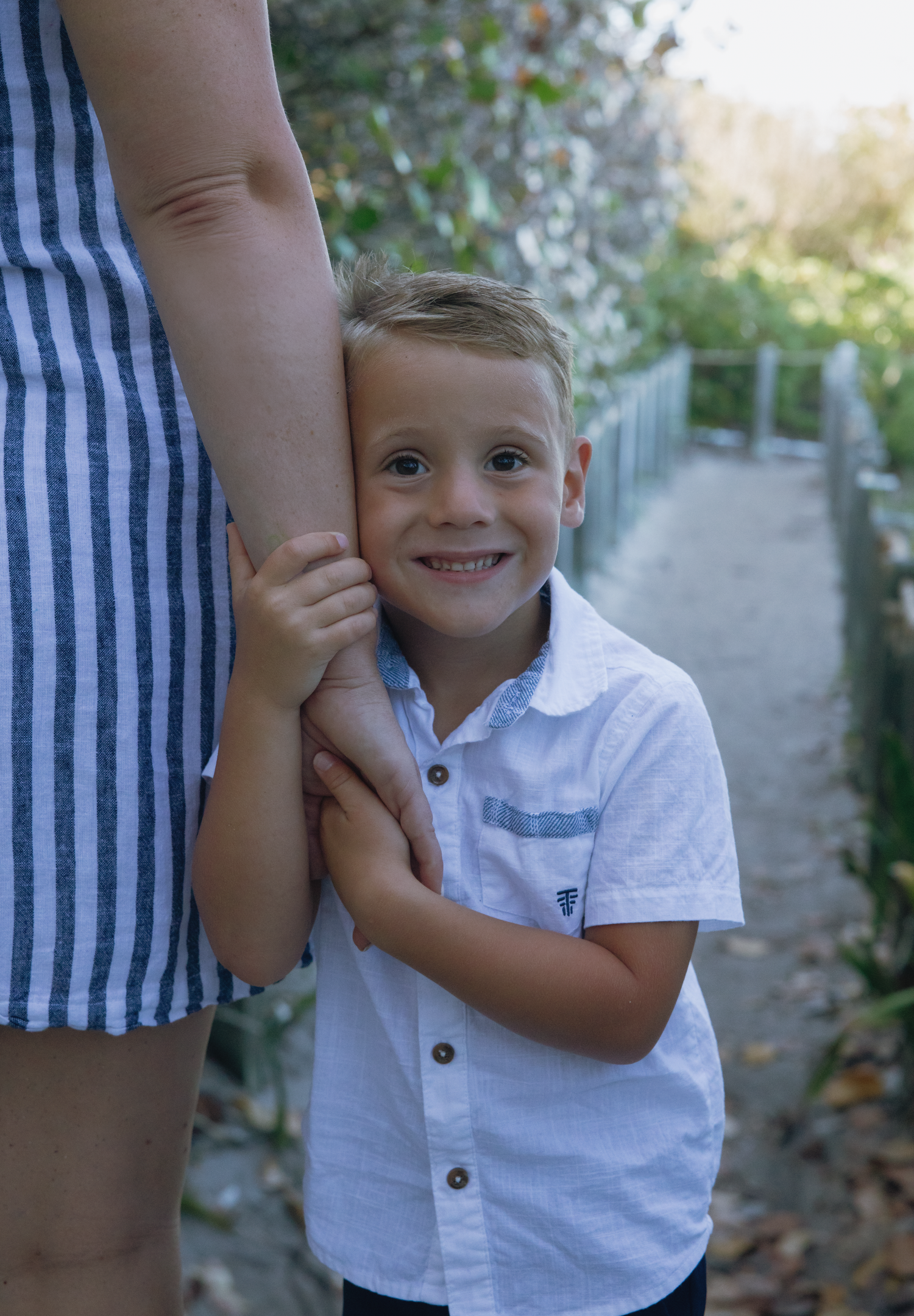 A series of candid moments showing a child in a white polo shirt playfully interacting with someone in striped clothing.