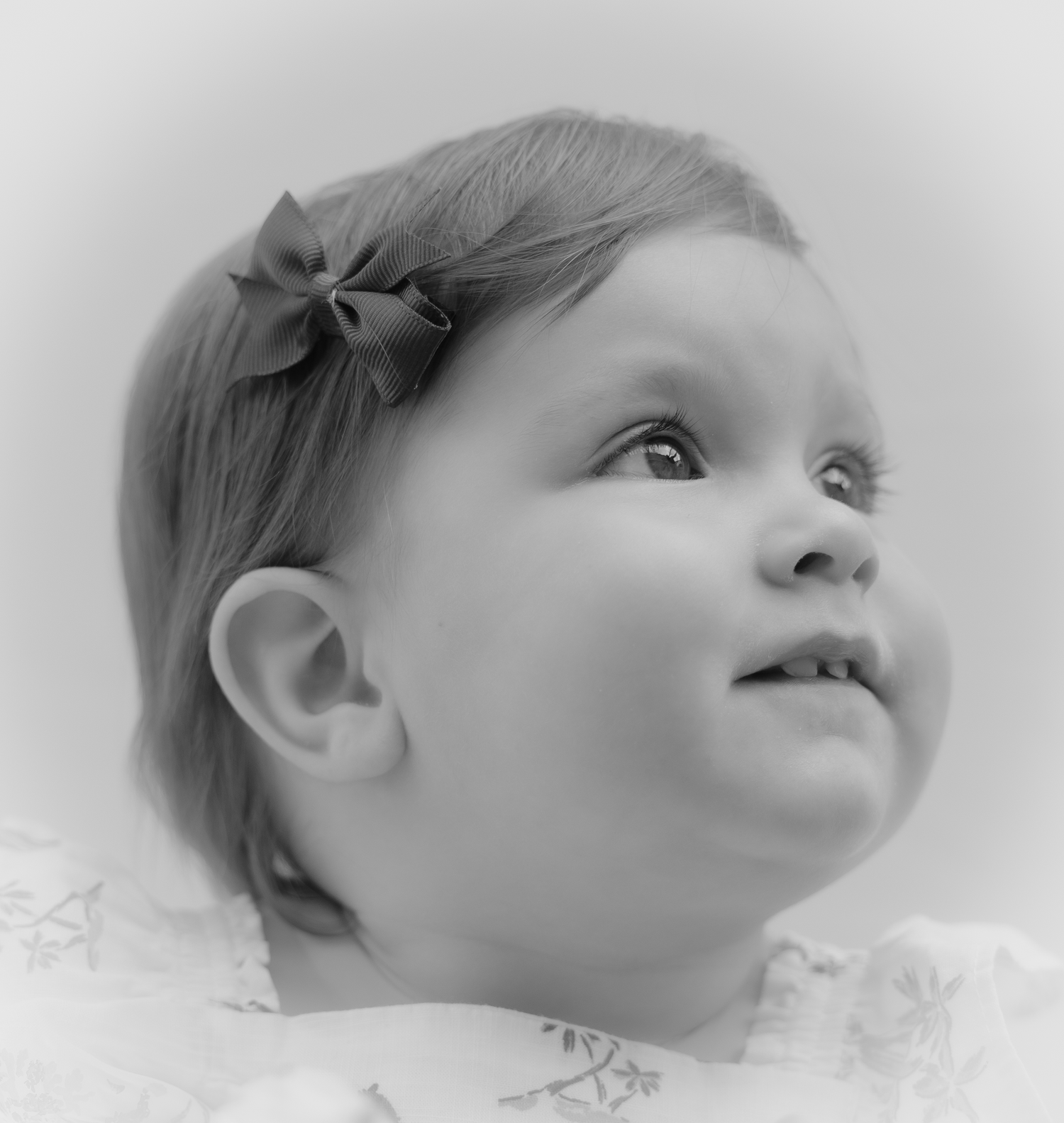 Black and white profile portrait of a baby looking upward with a serene expression.