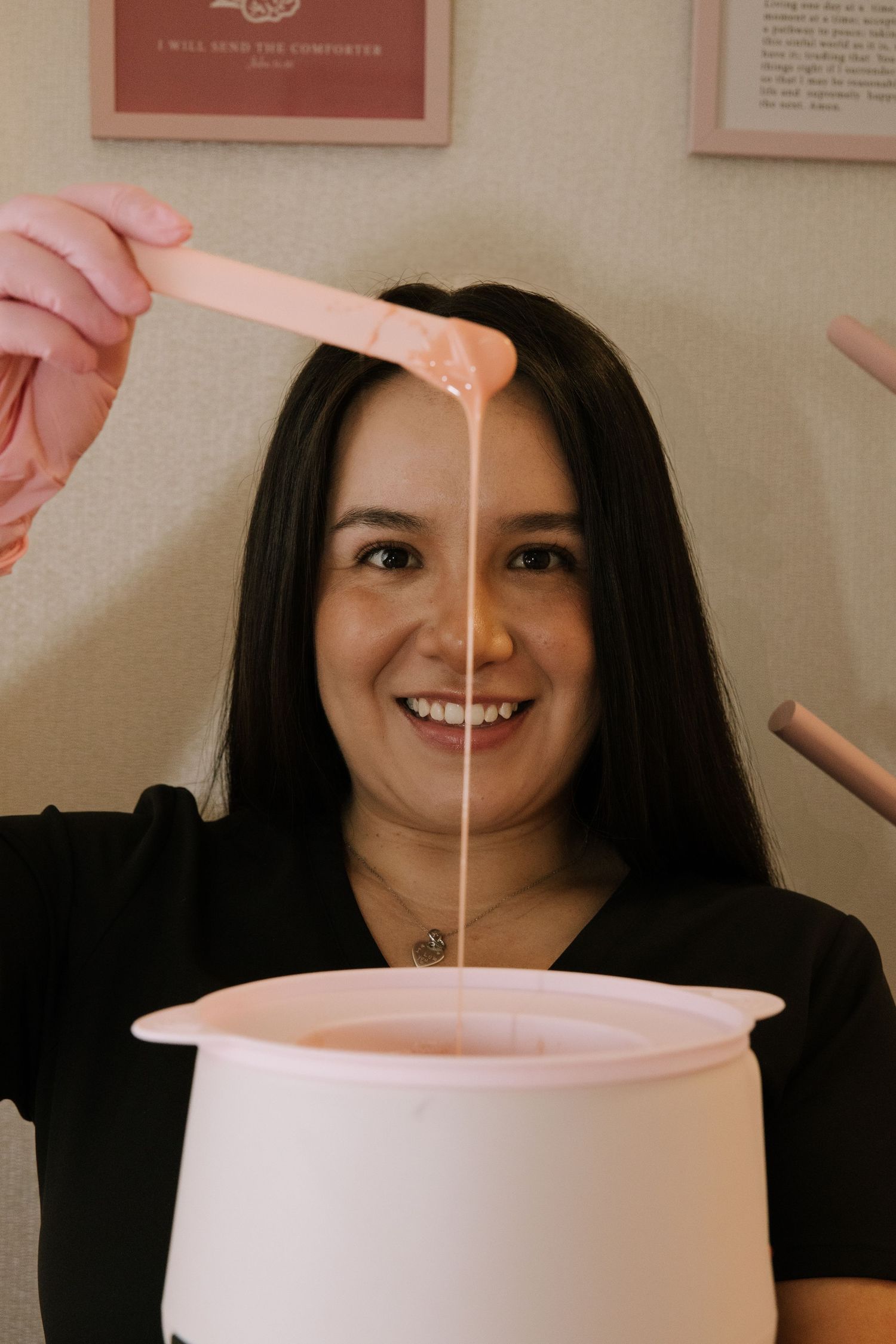 Person demonstrating wax application process with white pot and applicator.