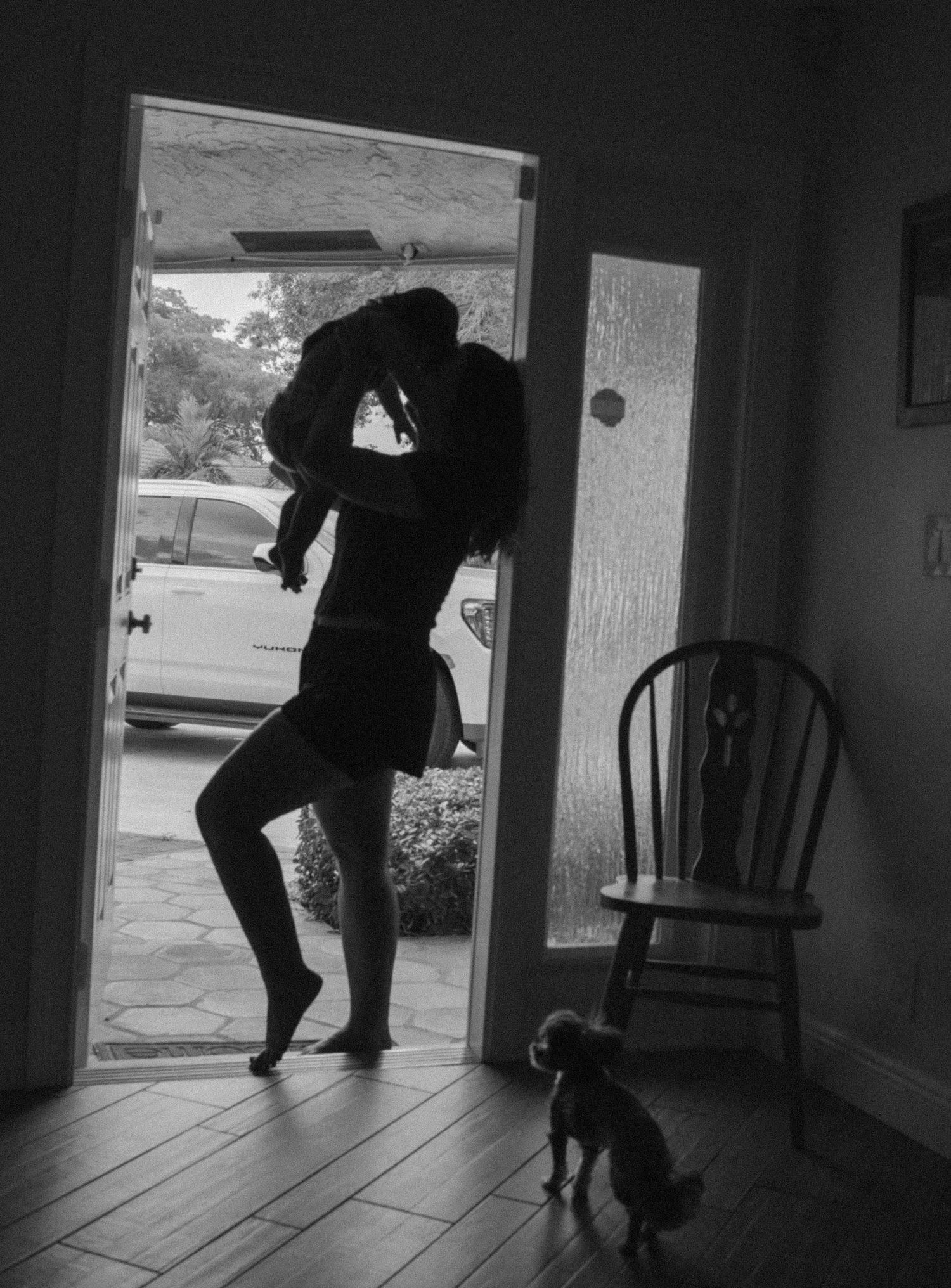 A sequence of black and white silhouettes shows a person dancing with a small dog in a doorway.