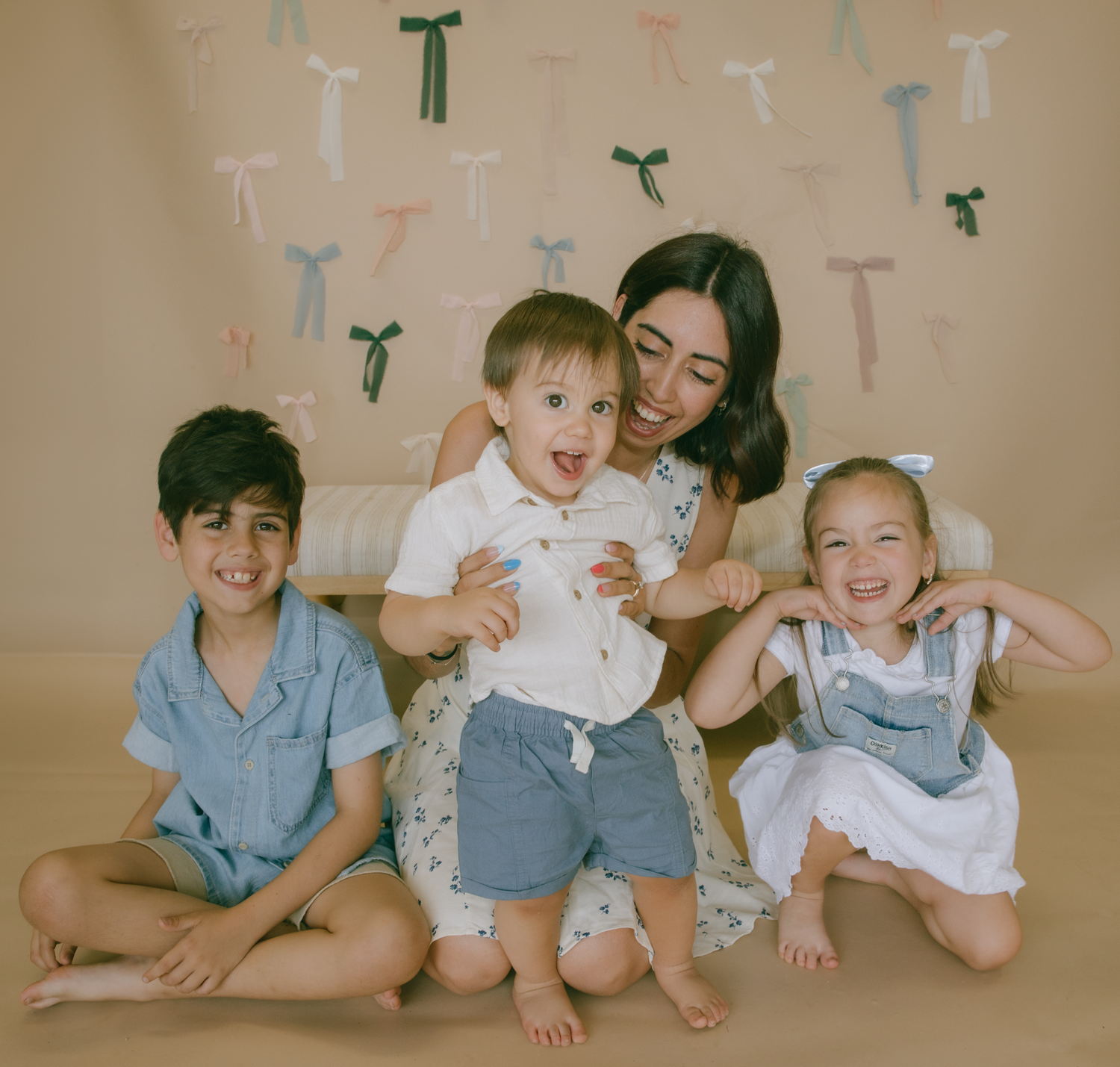 Joyful family photos showing playful moments together on a beige backdrop with colorful letter decorations.