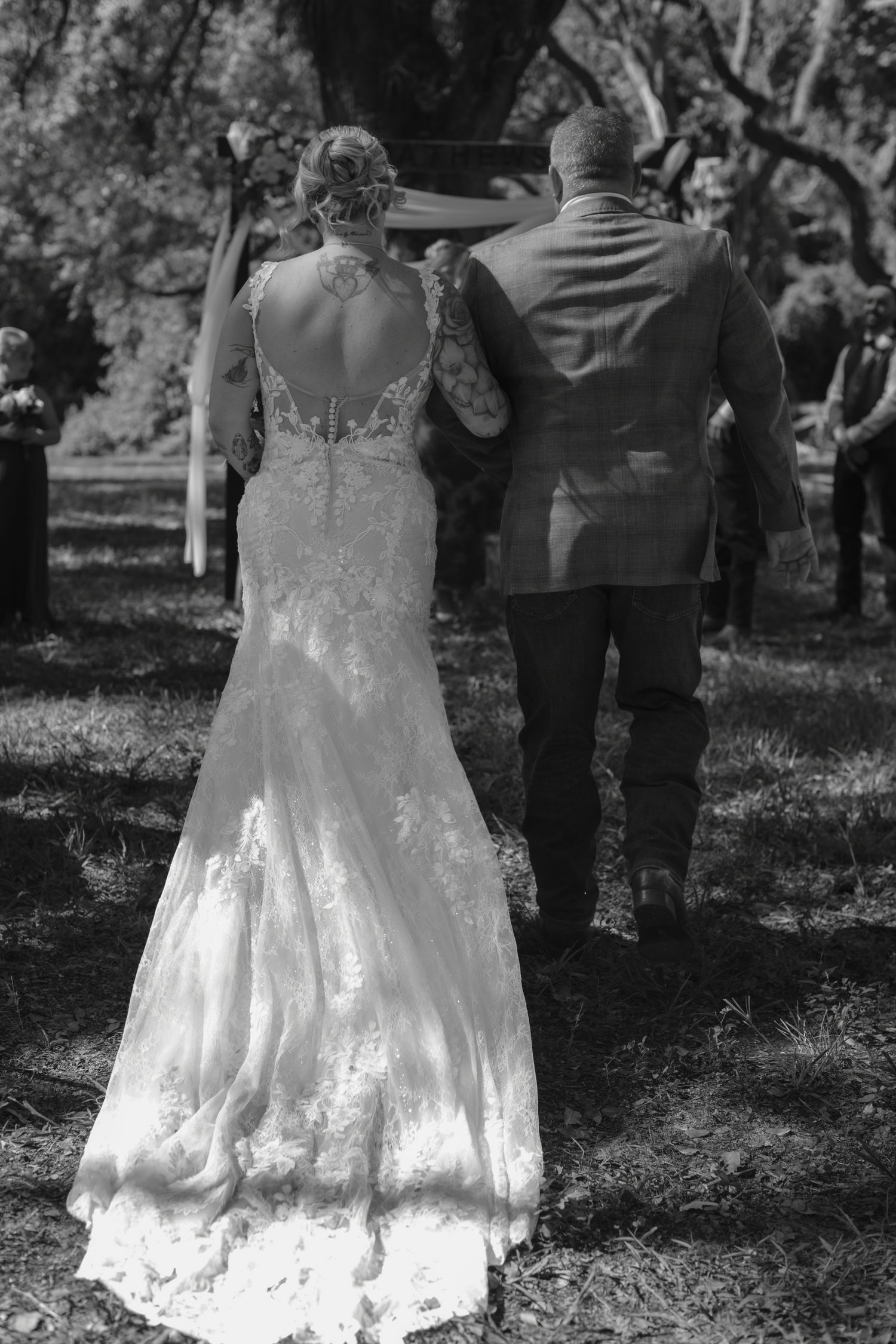 Black and white wedding photo sequence showing a couple dancing in a sunlit garden setting with a flowing lace dress.