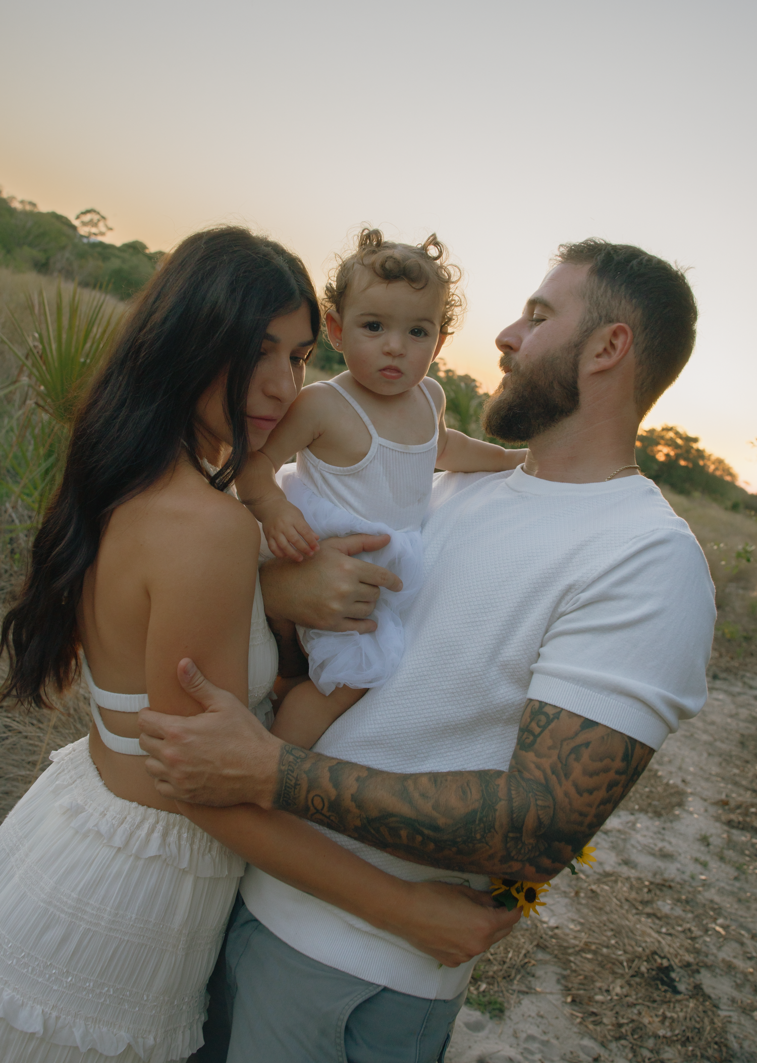 Sweet family embraces captured during outdoor sunset photoshoot.