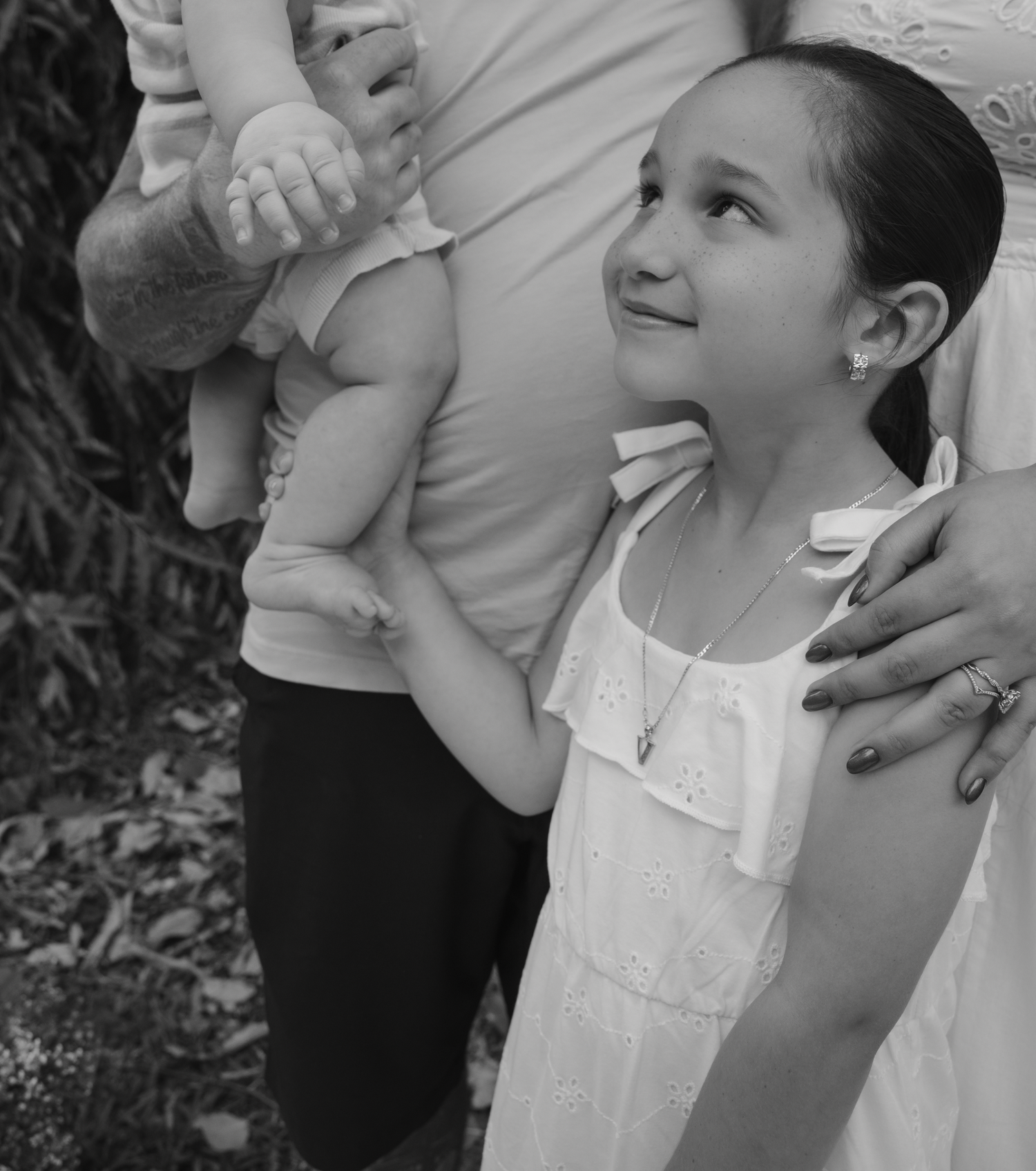 Candid family moments captured in black and white photography outdoors.