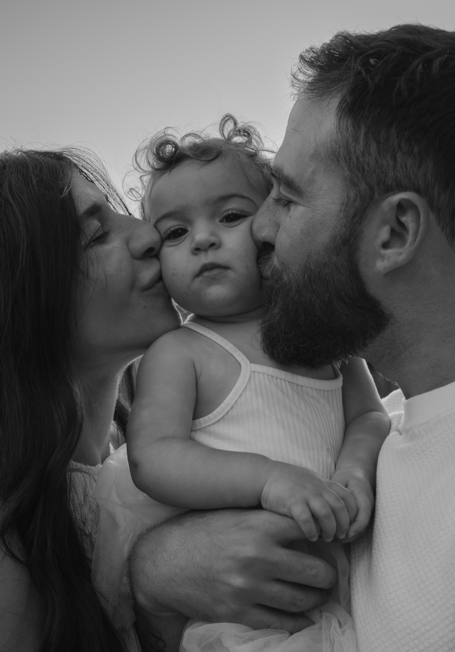 Black and white intimate family portrait showing loving embraces.