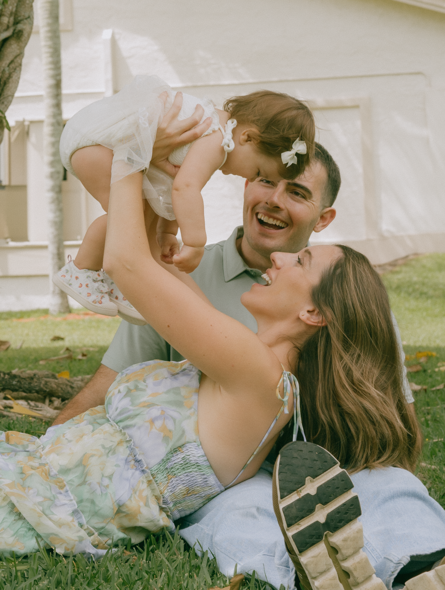 A couple lying on grass sharing joyful moments together in a romantic outdoor setting.