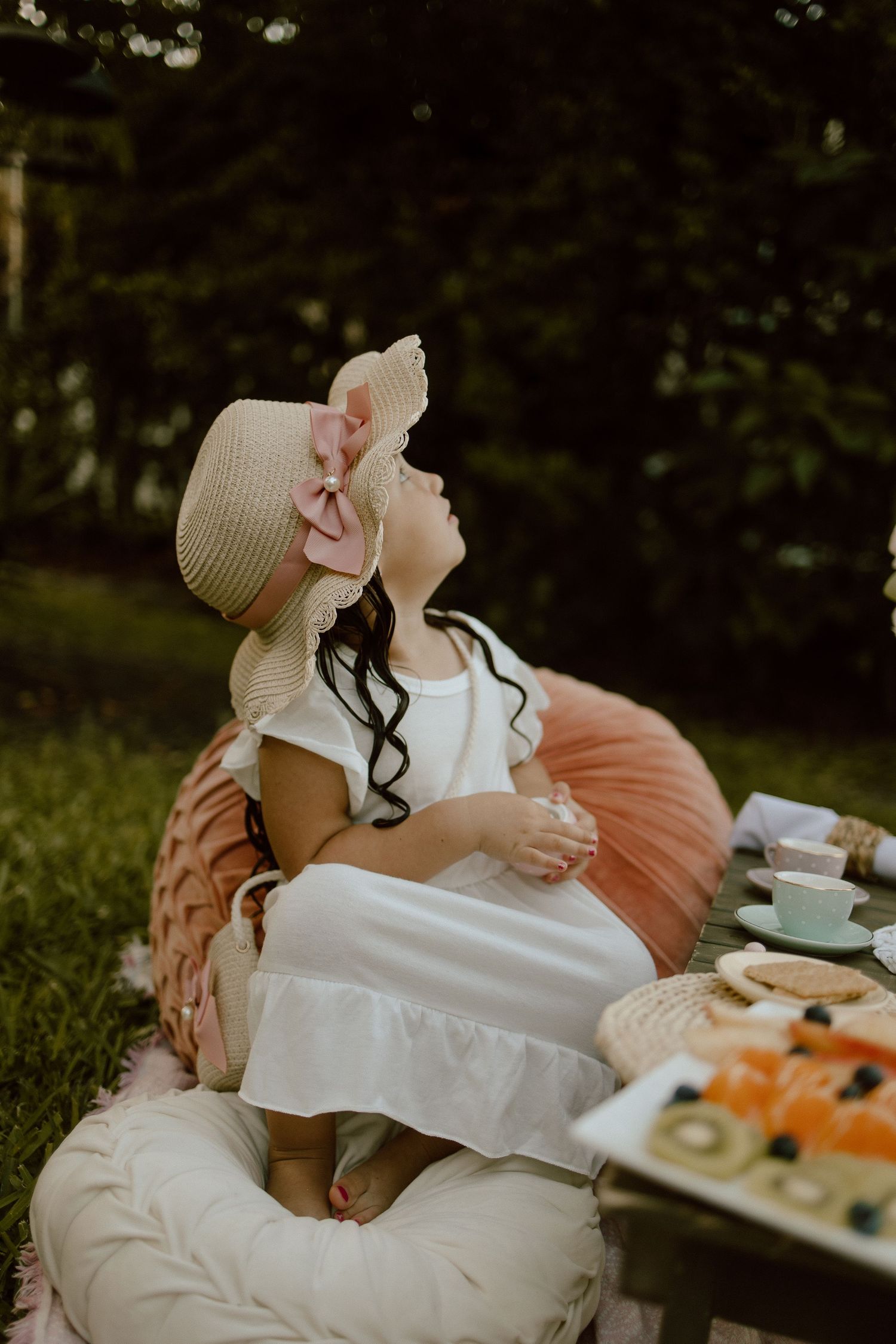 Dreamy outdoor tea party scene with soft lighting and vintage-inspired settings.