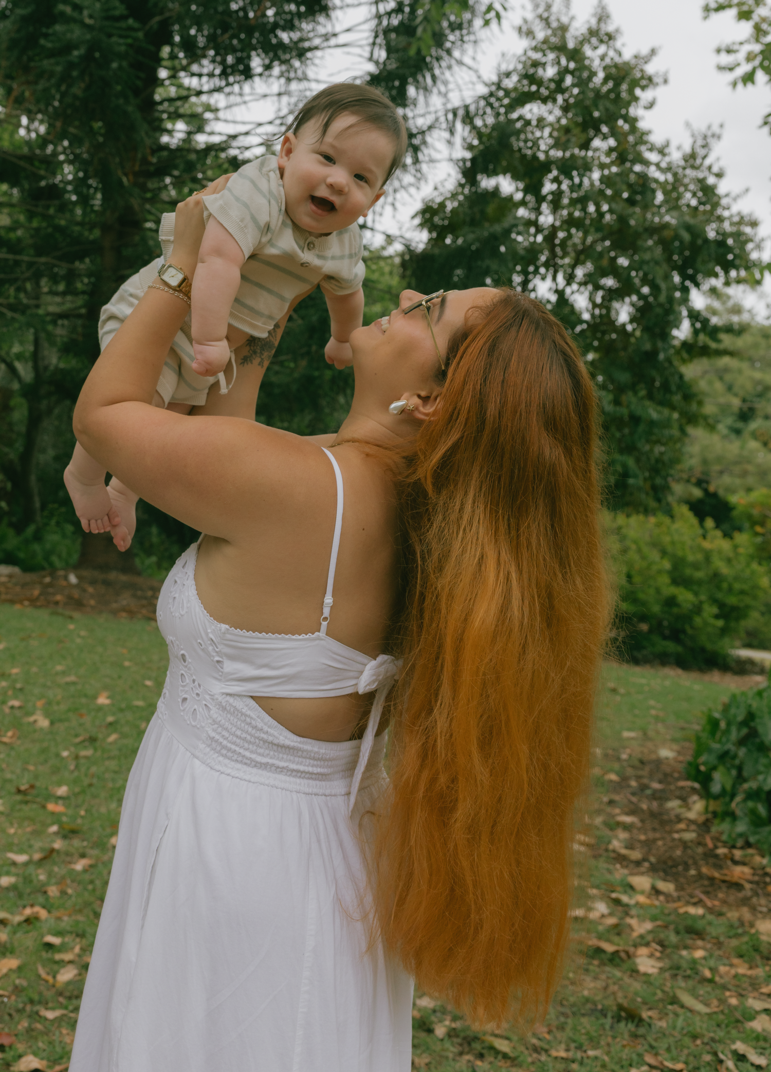 Series of playful family moments captured on white blanket in outdoor garden setting.