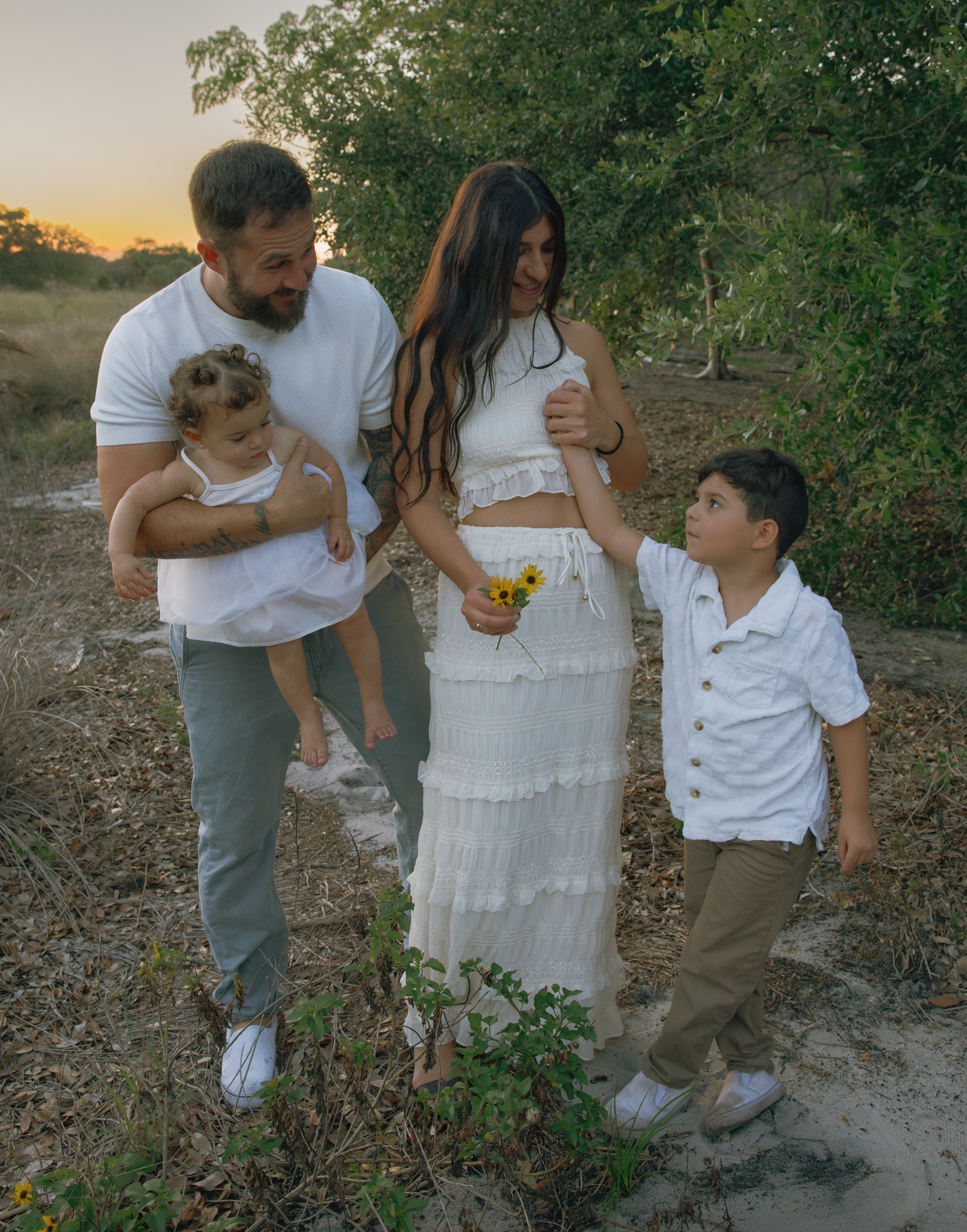 Family playing and embracing together outdoors on rugged natural terrain.