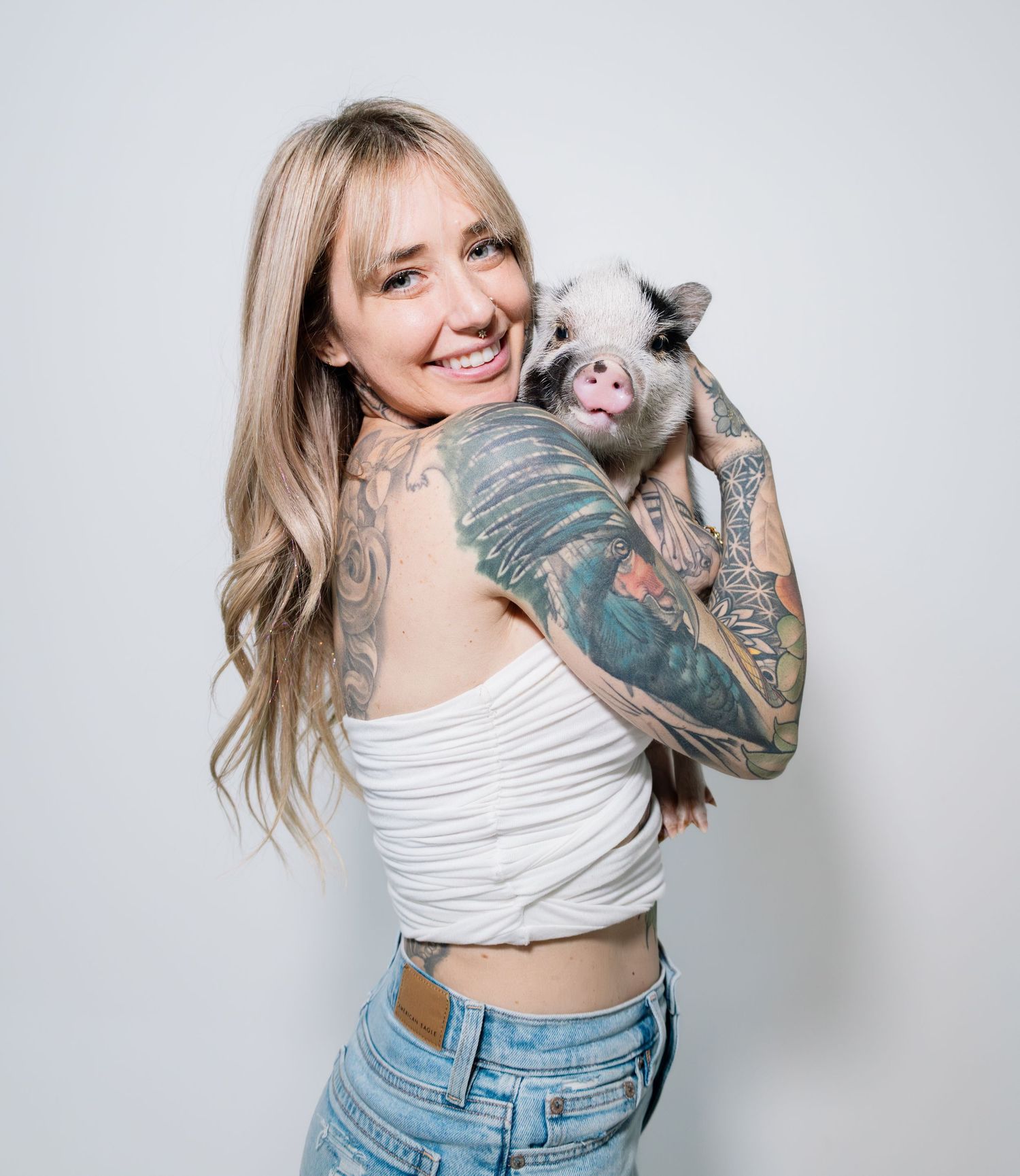 Person in white crop top and blue jeans poses playfully against white background in sequential photo series.