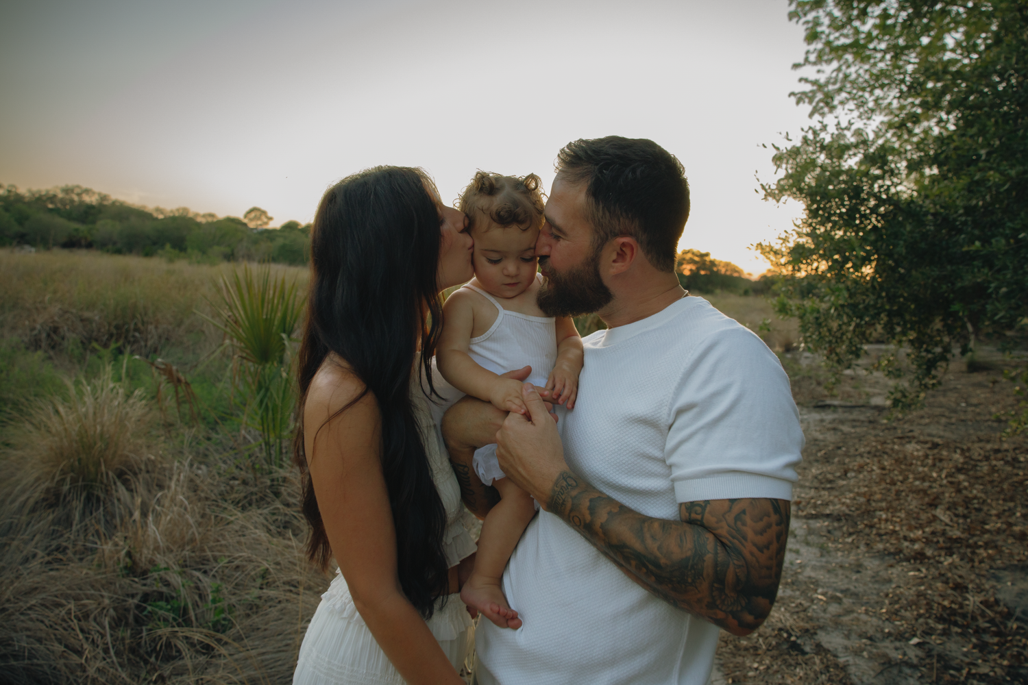 Family sharing affectionate moment during sunset outdoor session.