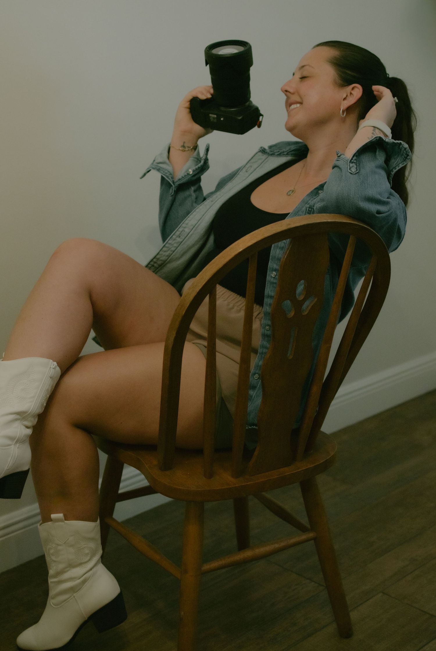 A woman in white socks sits back in a wooden vintage chair shown from multiple angles on a dark floor.