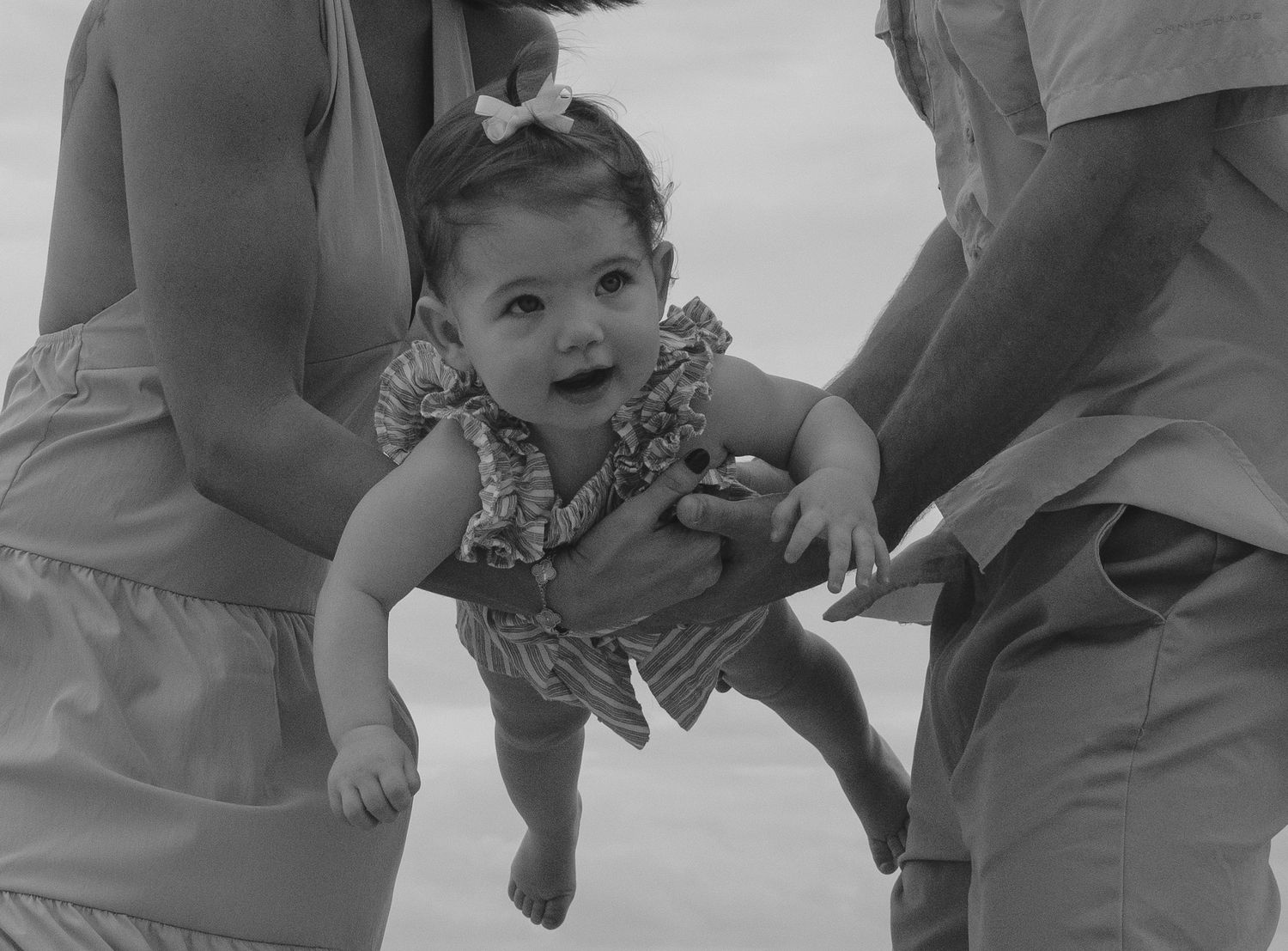 A series of black and white photographs showing a baby's joyful expressions and reactions in different moments.