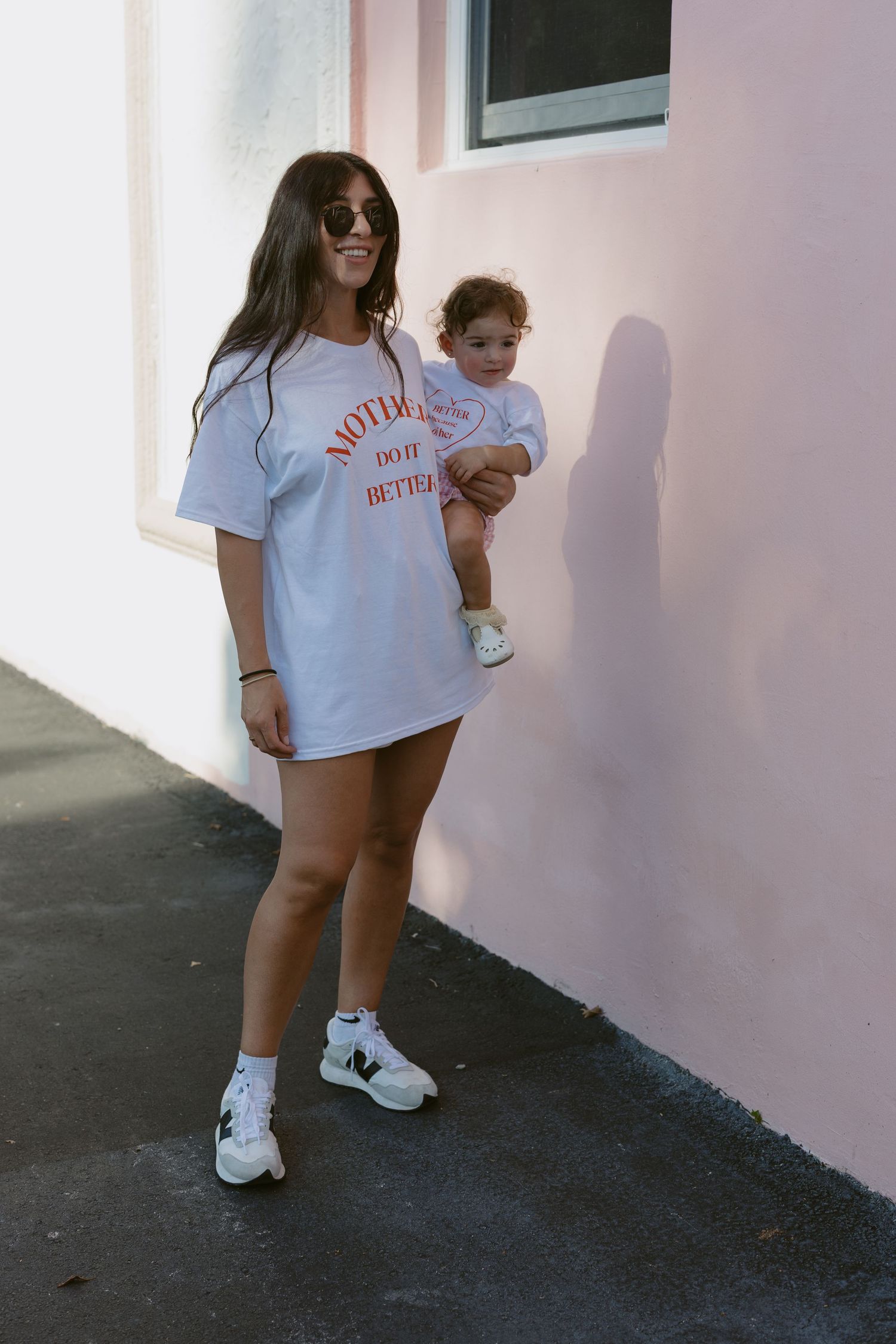 A person in a white t-shirt and white sneakers stands against a pink wall in a series of four similar photos.