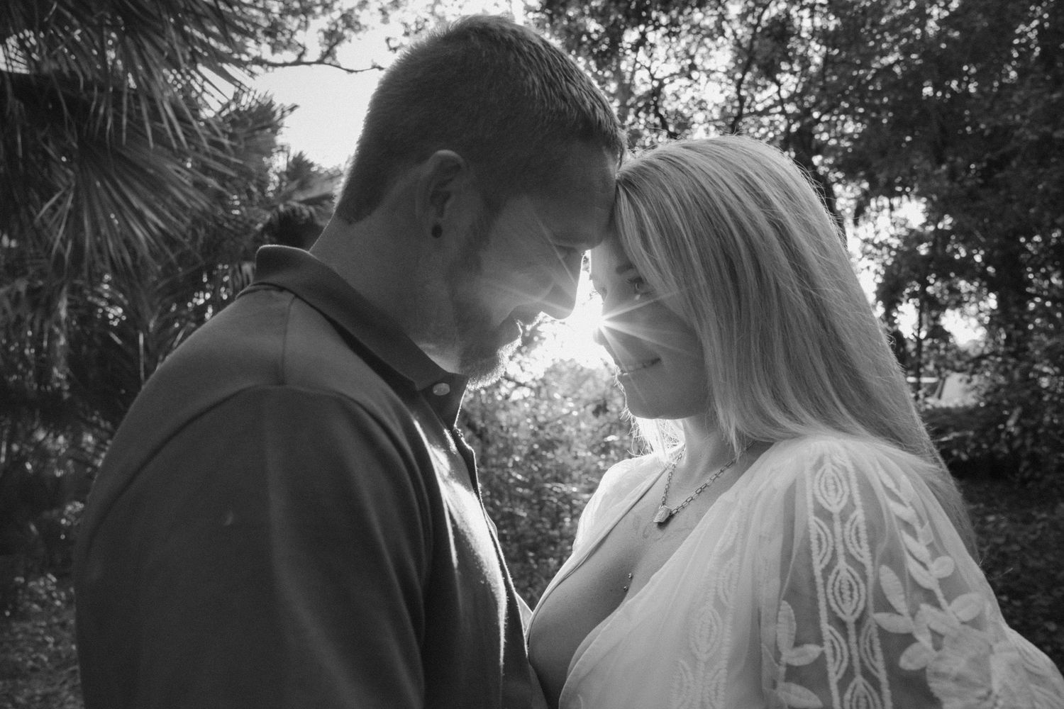 An intimate black and white portrait captured during sunset in a natural outdoor setting.