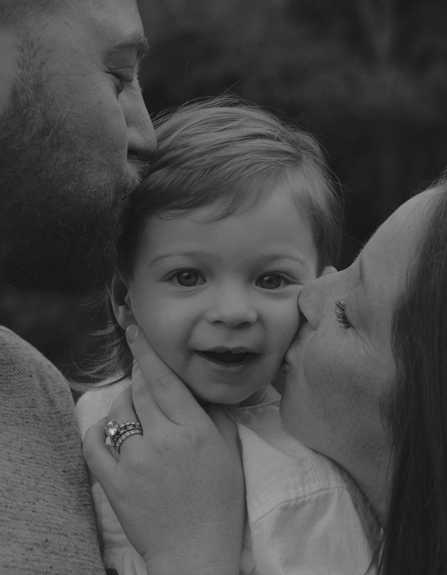 A series of black and white photos showing tender moments between a parent and child in close-up shots.