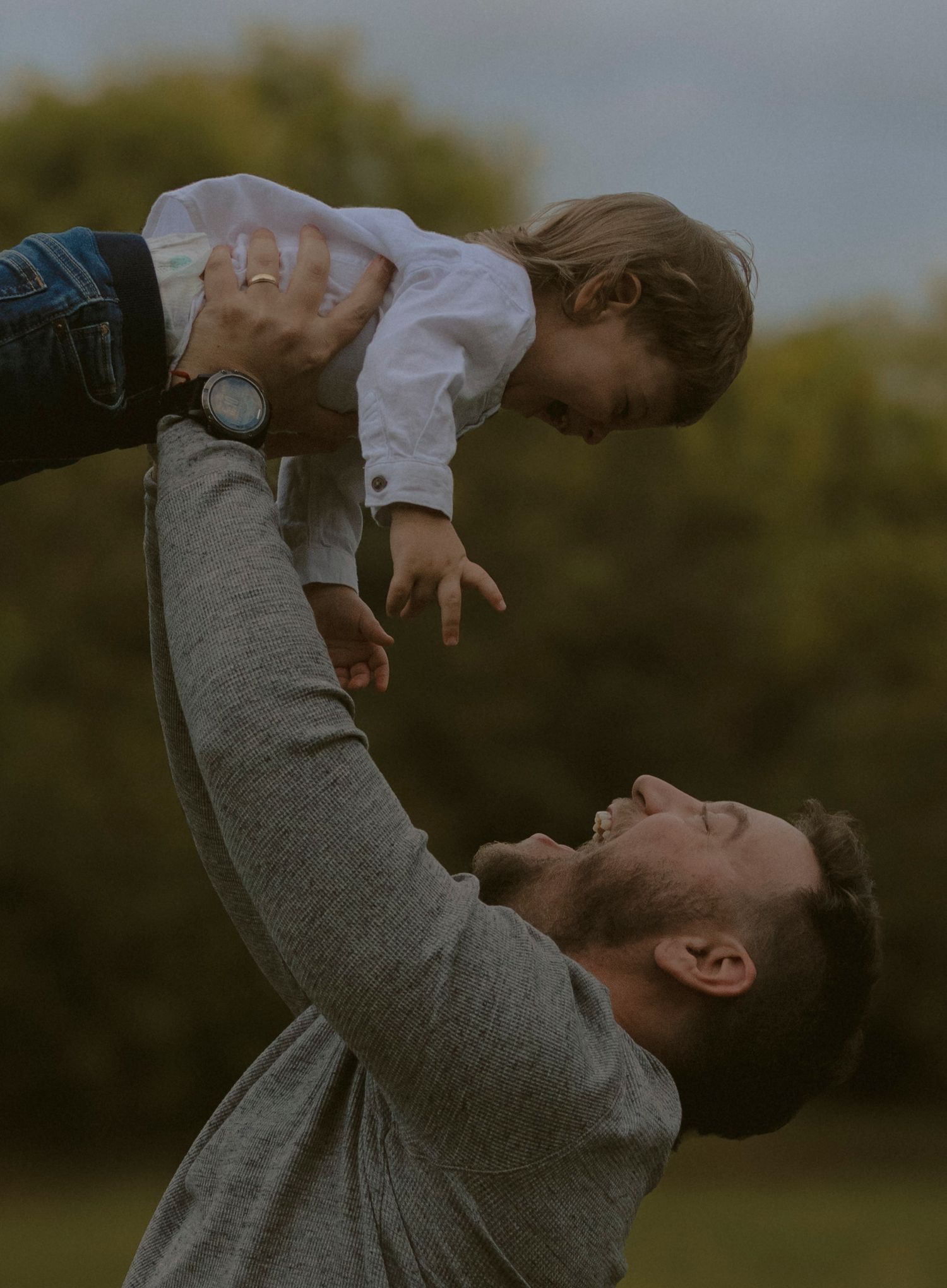 A series of candid moments showing a parent lifting and playing with a small child outdoors at sunset.
