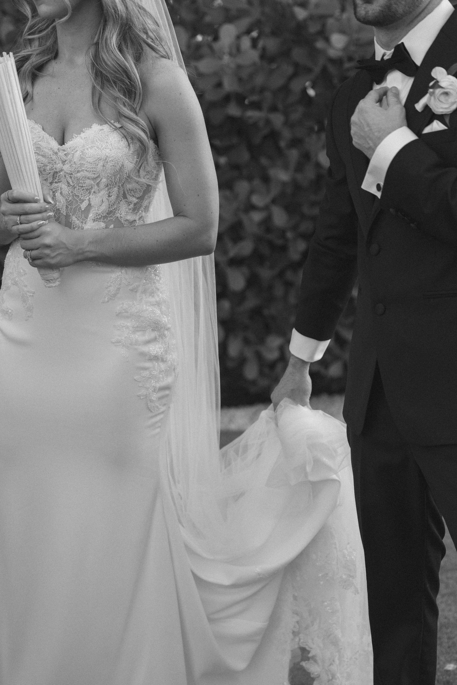 A series of black and white wedding photos showing close-up details of a bride in a white lace dress during the ceremony.