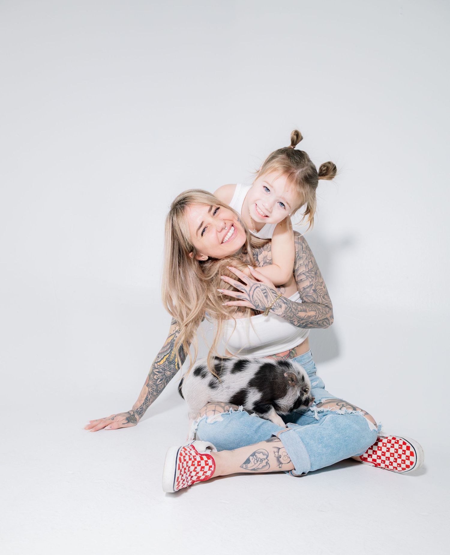 A joyful family moment with a black and white rabbit on a light gray background.
