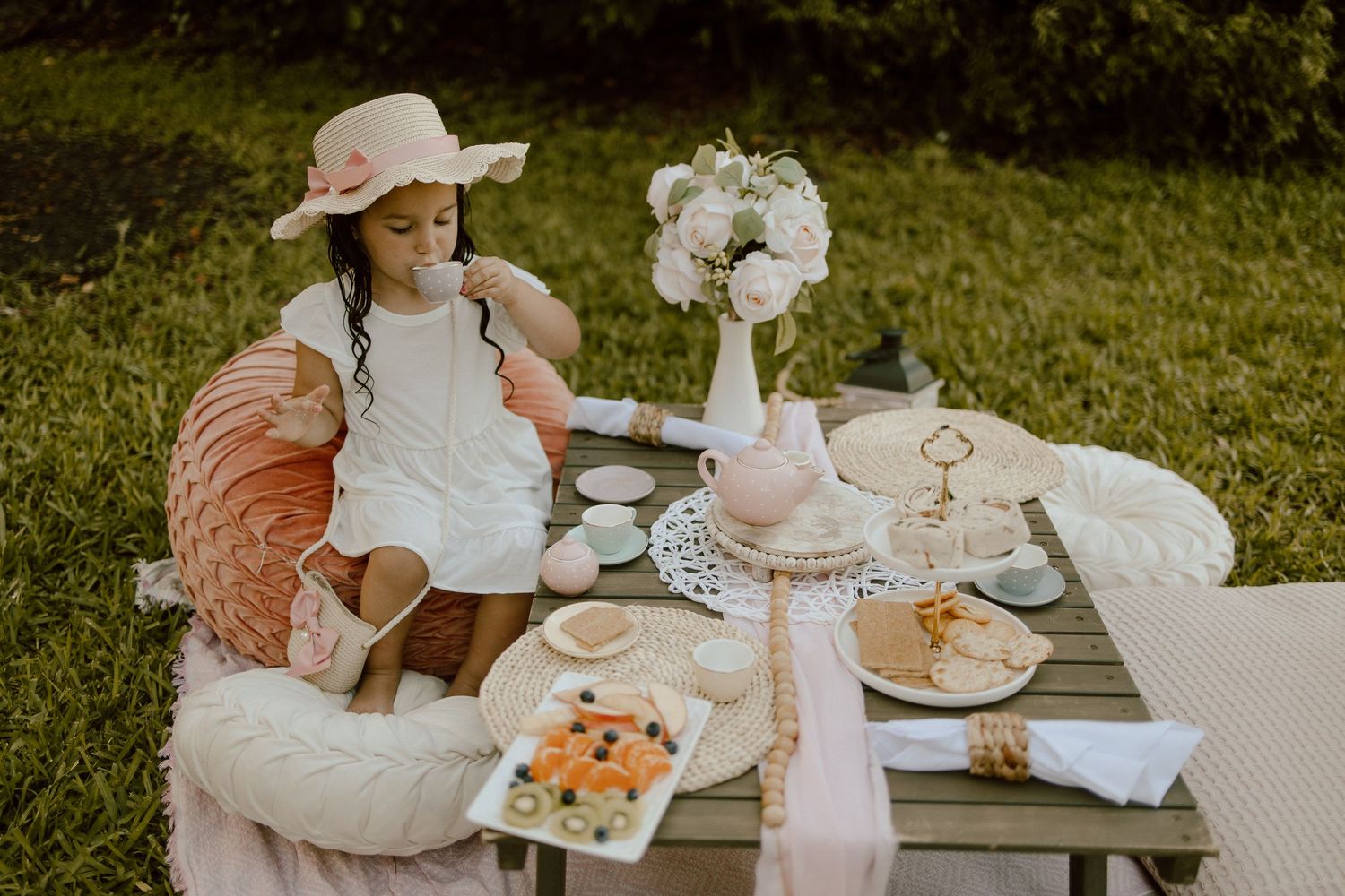 Enchanting garden tea party setup with pink accents and delicate white florals.