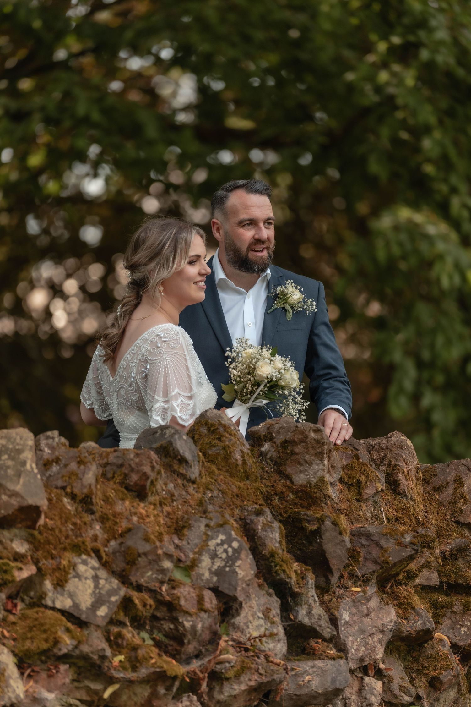 Romantic portrait on weathered stone wall with natural garden backdrop.
Malvern hills council house wedding venue