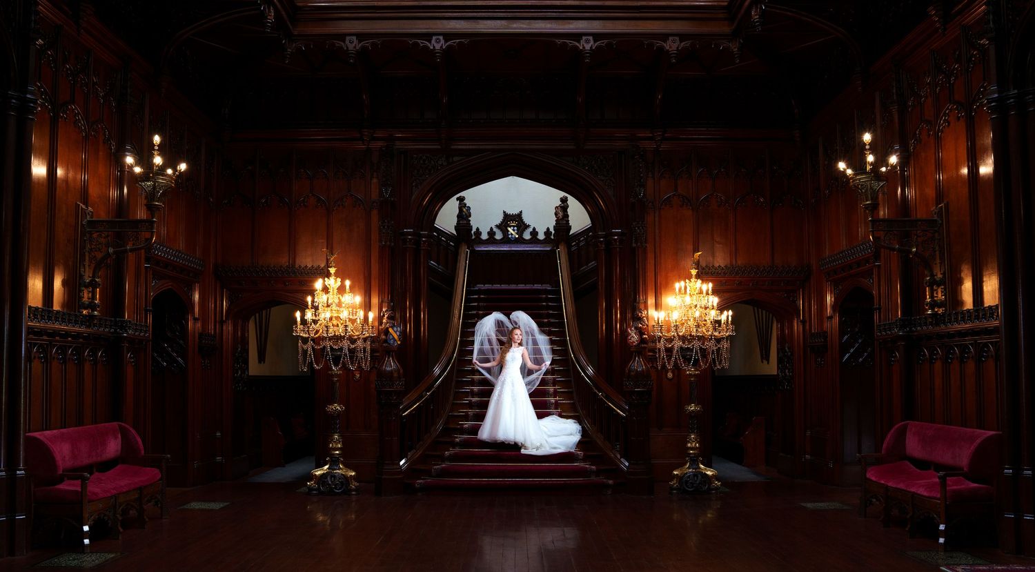 Elegant ballroom venue with ornate chandeliers and illuminated wall sconces creating a romantic ambiance.