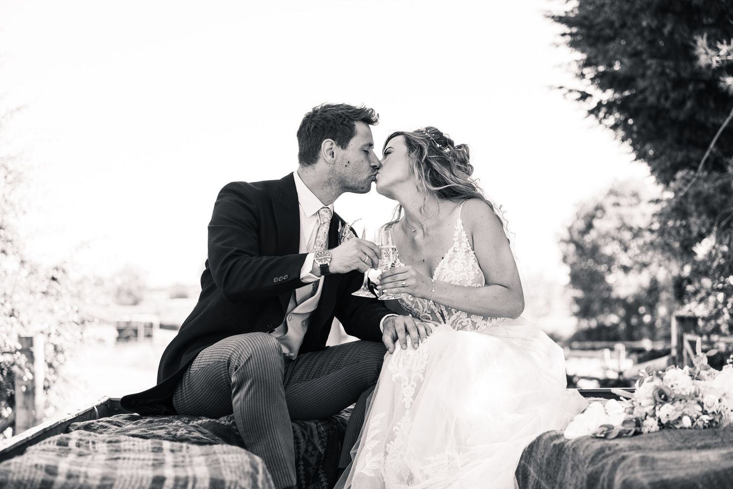 A black and white wedding photo collage showing romantic moments between the couple outdoors.