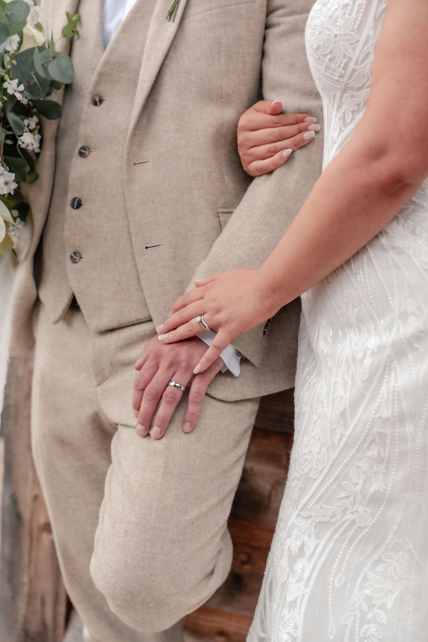 Close-up of newlyweds' hands showing wedding rings against formal attire.
The Mill Barns wedding venue