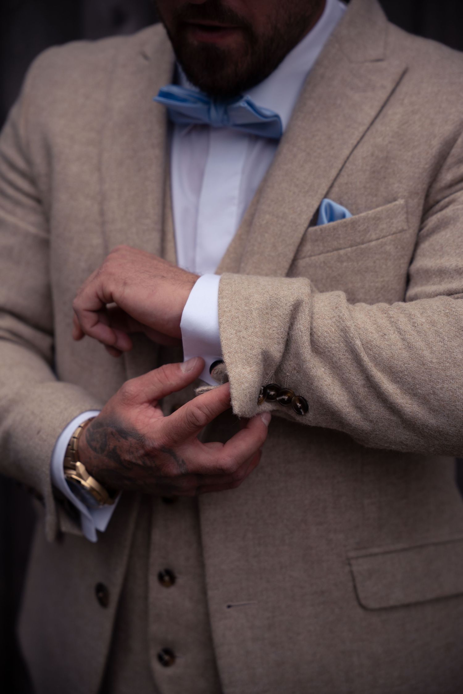 Close-up of beige suit jacket with blue pocket square detail.
The Mill Barns wedding venue