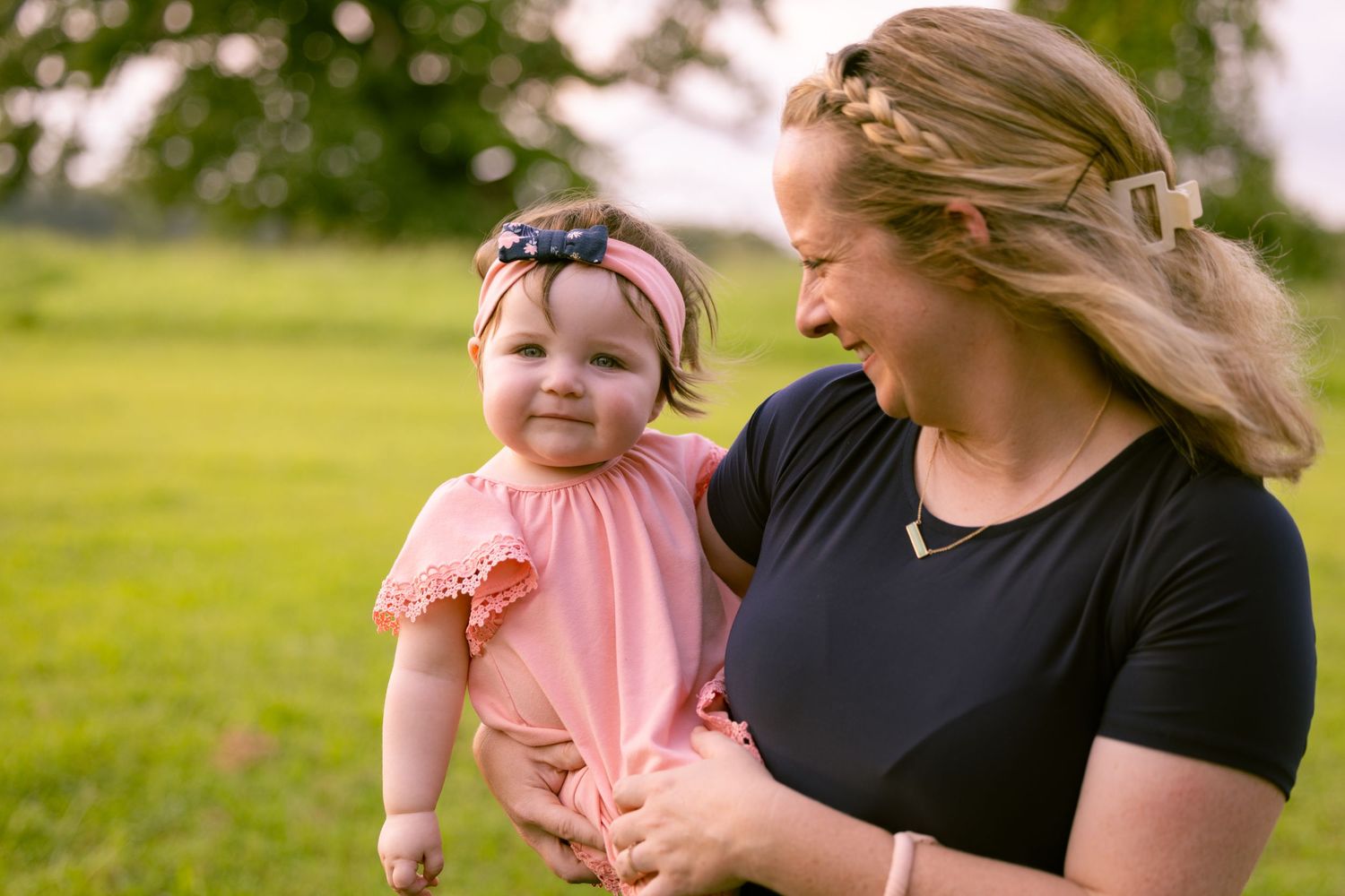 Family enjoying outdoor time together on grassy field in summer.