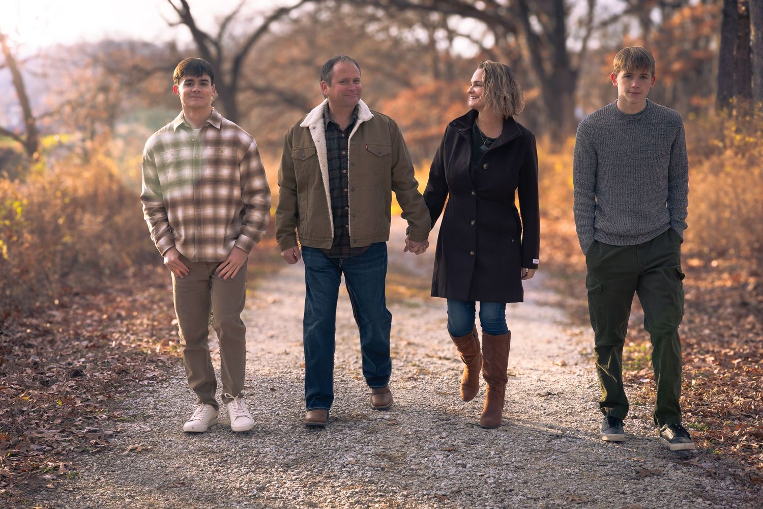 Group walking together on autumn trail surrounded by fallen leaves.