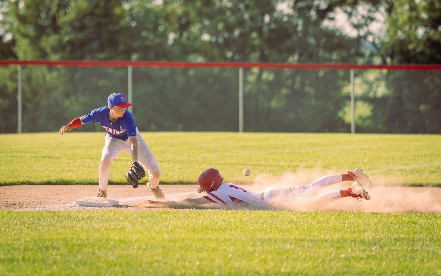 Baseball players positioned on field during afternoon game.