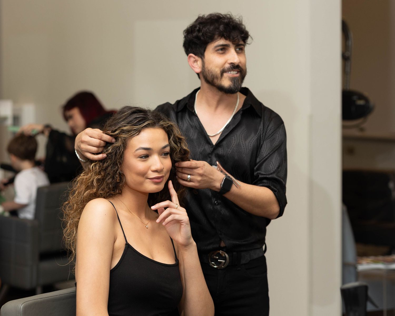 Hairstylist working on client's hair in professional salon setting.