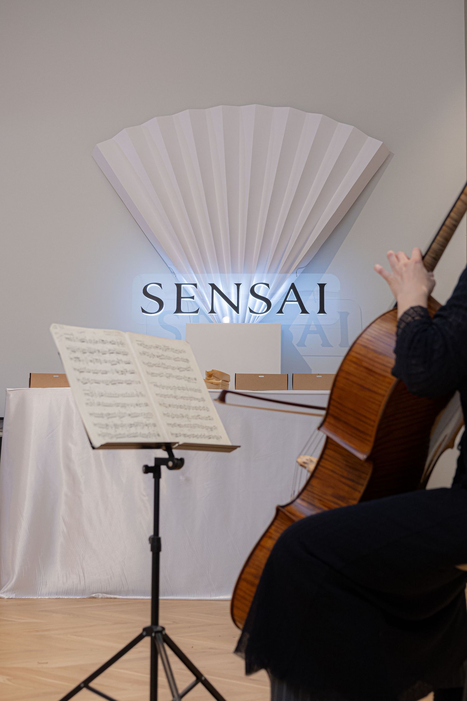 Music stands with sheet music arranged in front of white backdrop with Sensai branding.