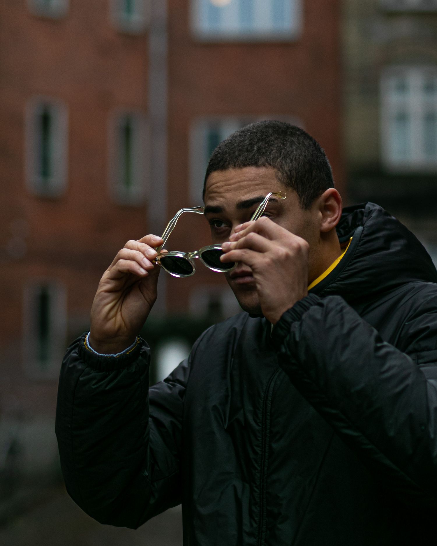 Sequence of someone adjusting sunglasses in an urban setting.