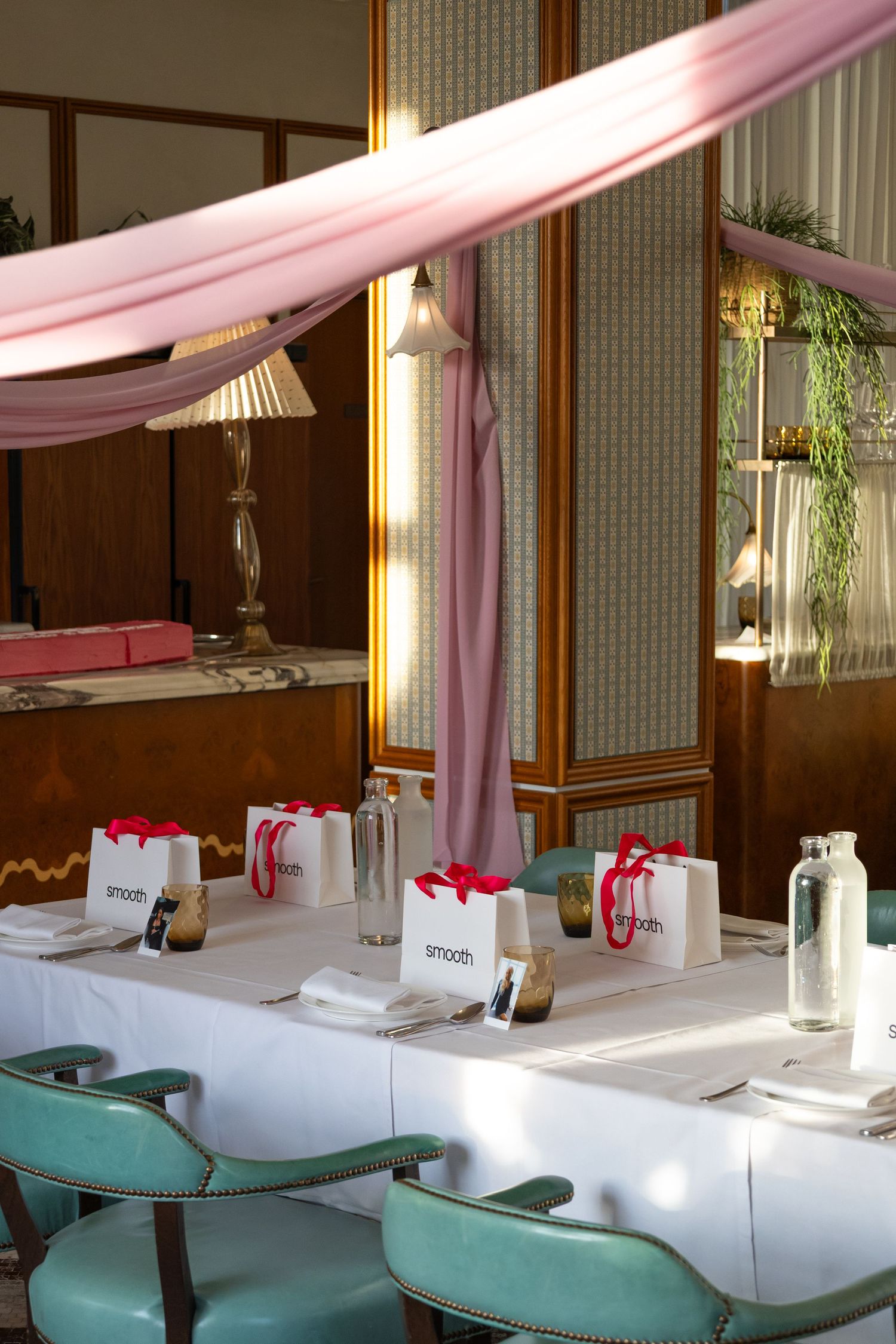 Luxurious spa interior with turquoise chairs and pink draping fabric creating elegant ambiance.