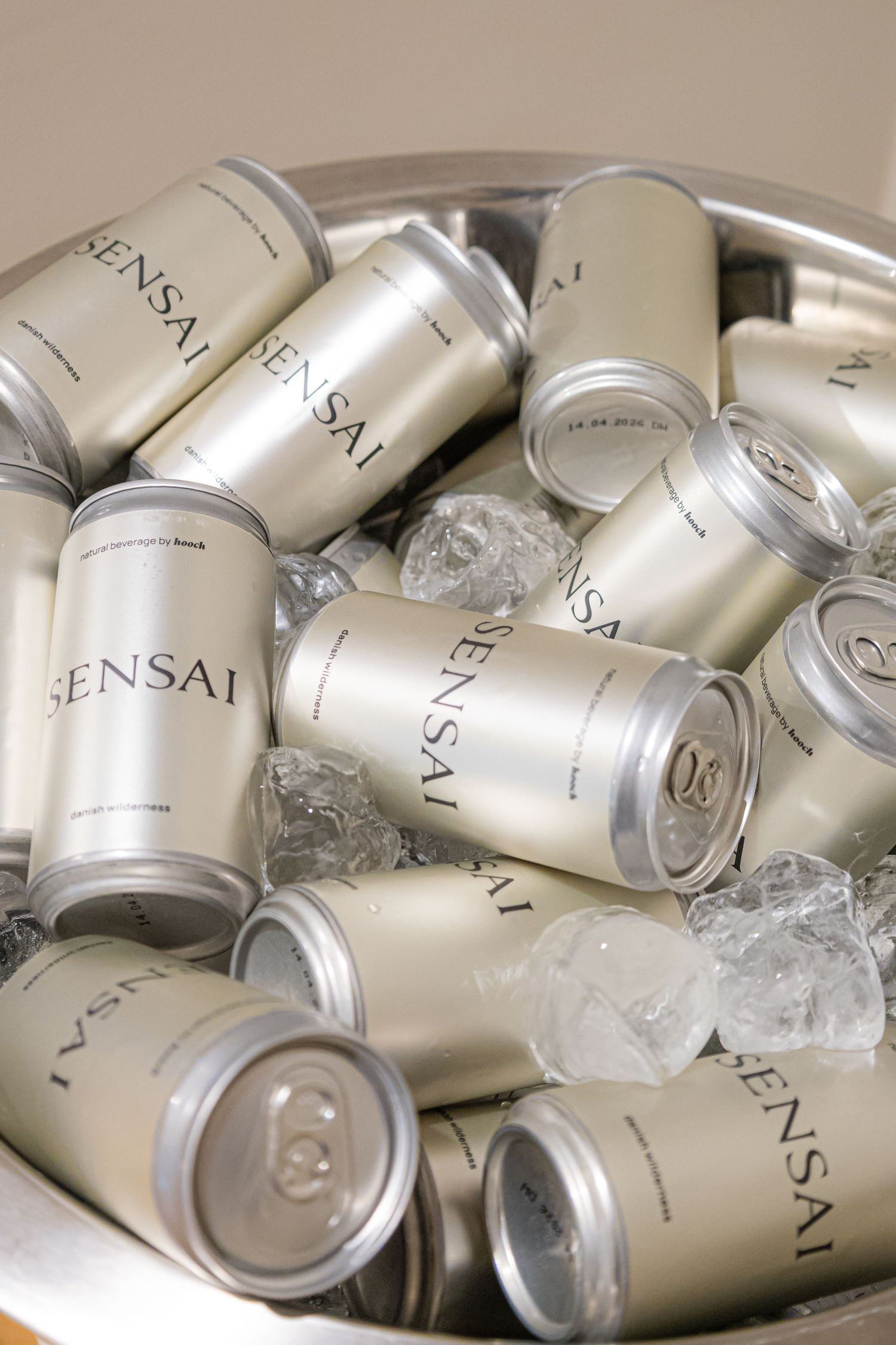 Collection of silver Sensai beauty product containers arranged together.