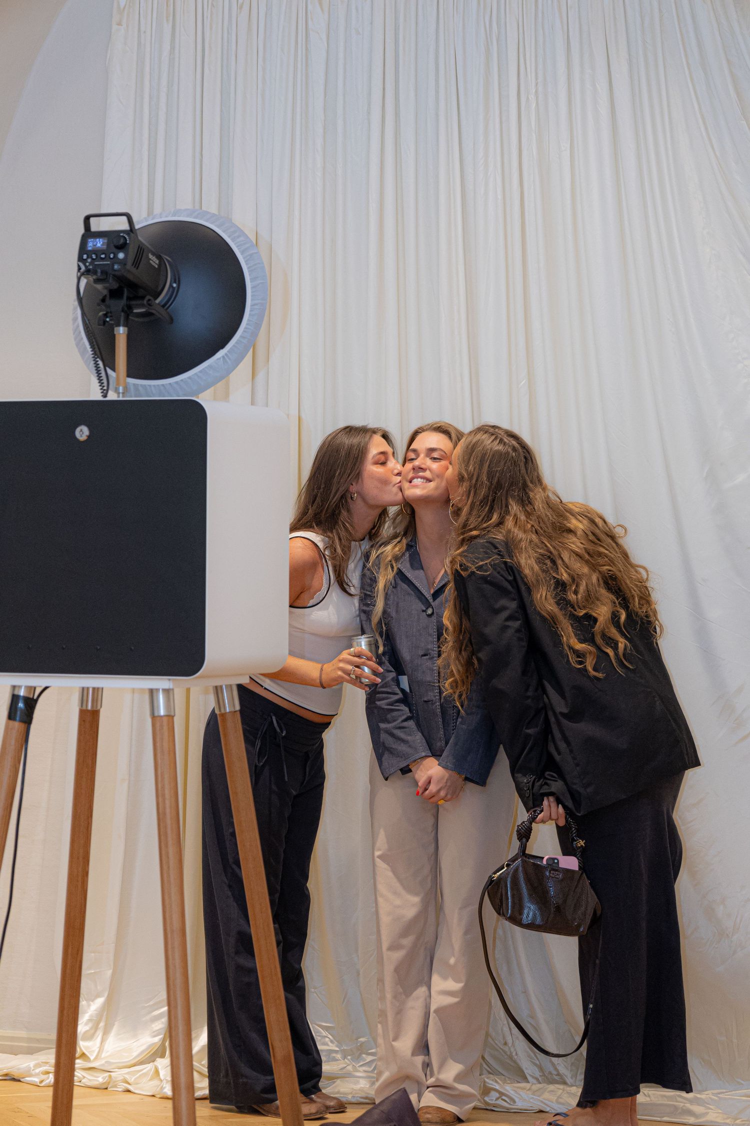 People gathered around photography equipment in a studio with white backdrop.