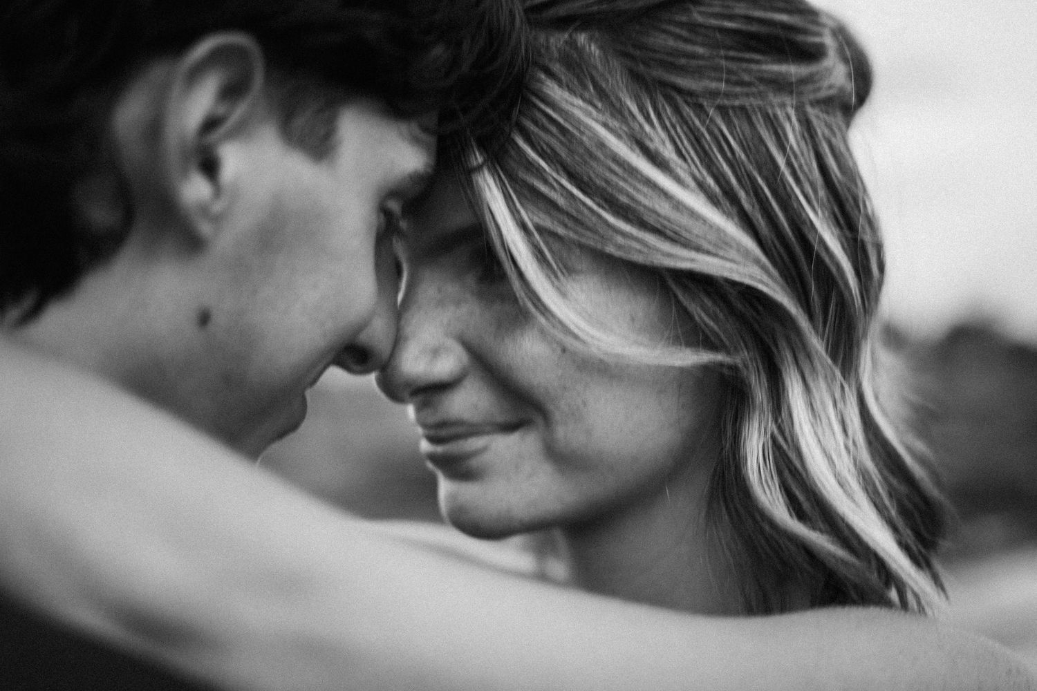 Intimate black and white close-up portrait of couple sharing tender moment.