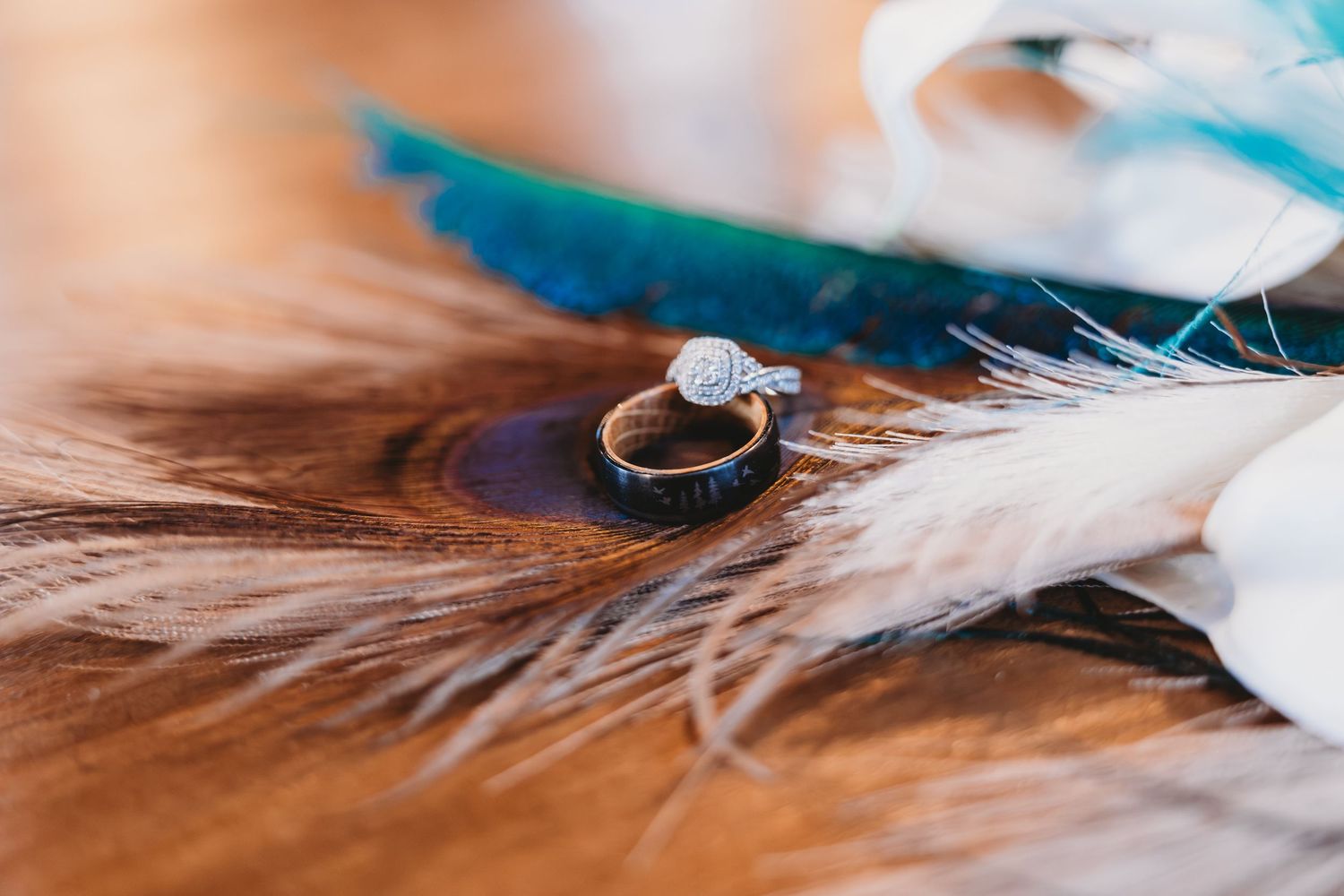 Engagement ring with gemstone placed on feather with turquoise accents.