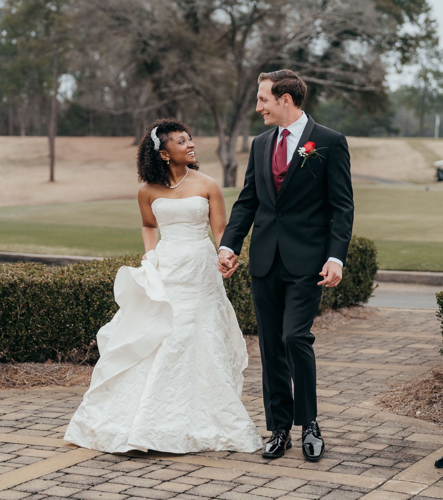A romantic wedding portrait on a stone pathway outdoors.