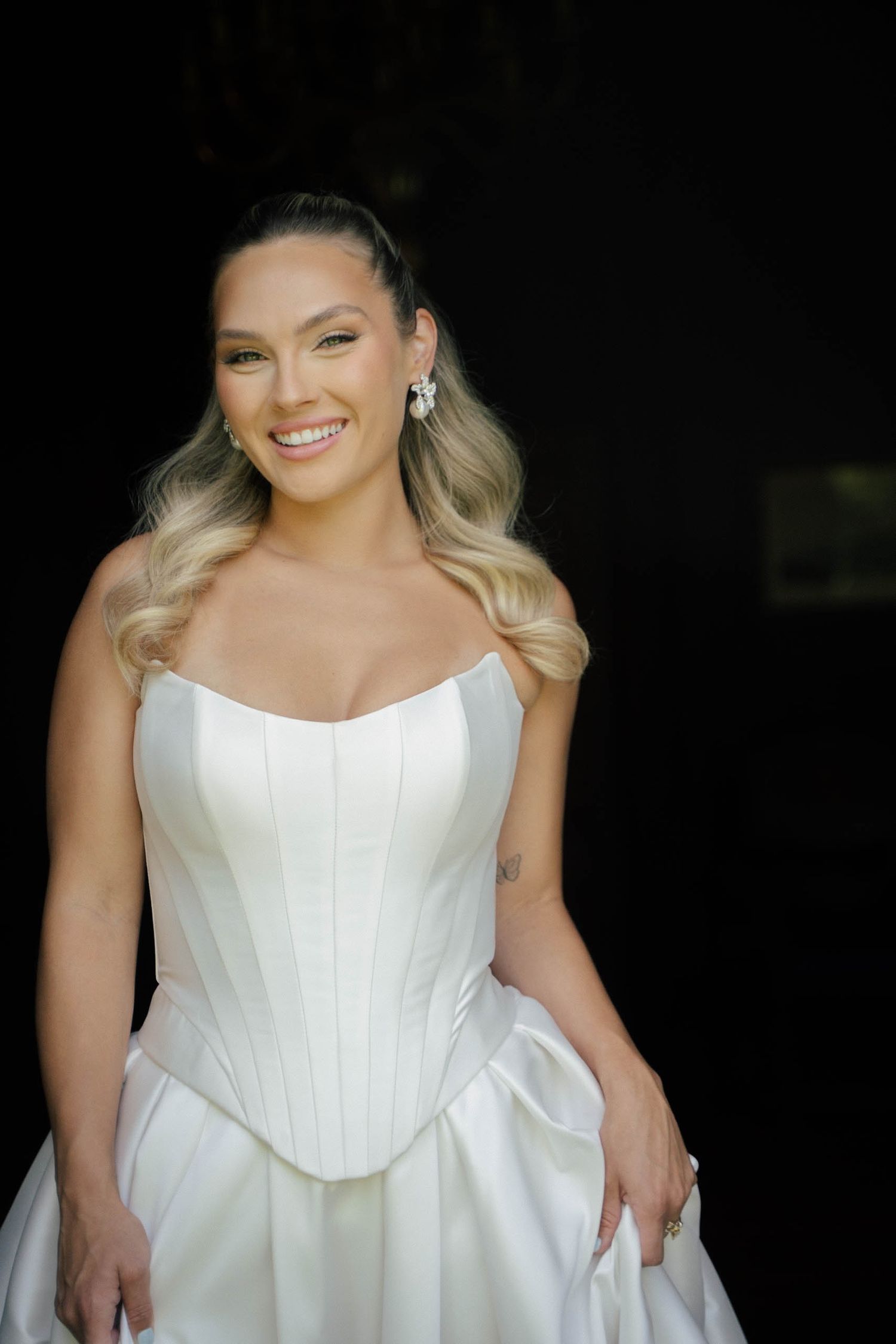 Bride in an elegant white strapless wedding dress poses gracefully from multiple angles.